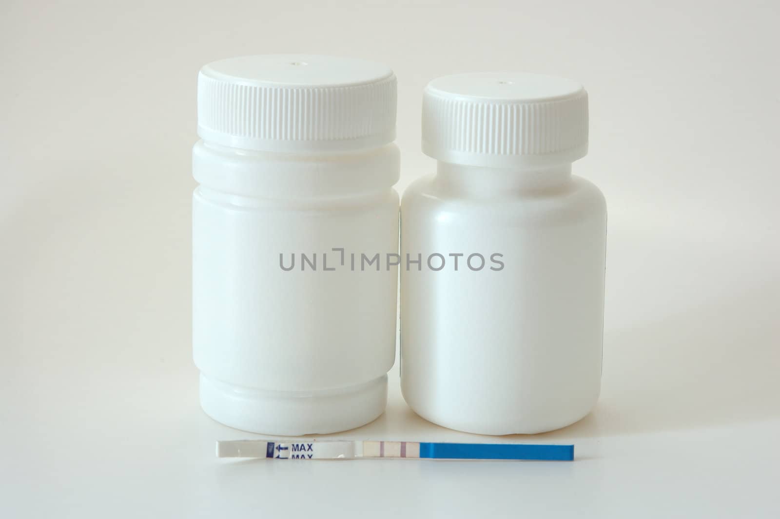 Confirmative pregnancy test and two drug's (vitamins) bottles.