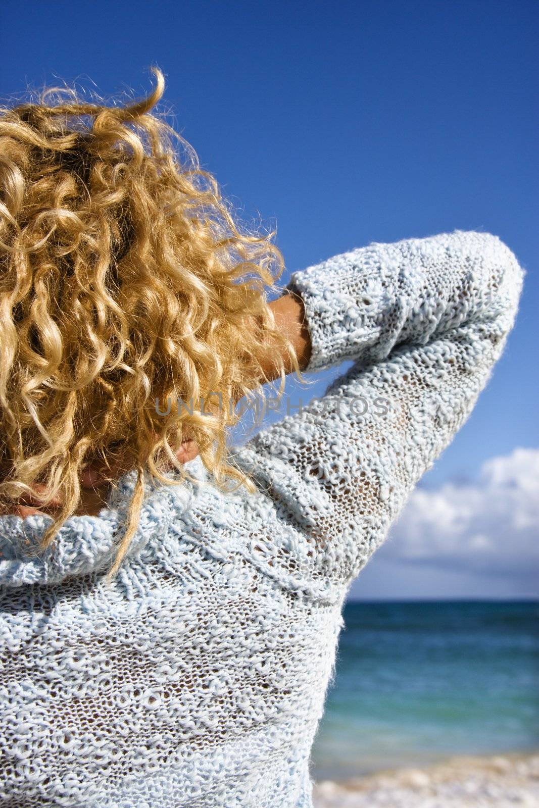 Portrait of woman standing on Maui, Hawaii beach looking at ocean.