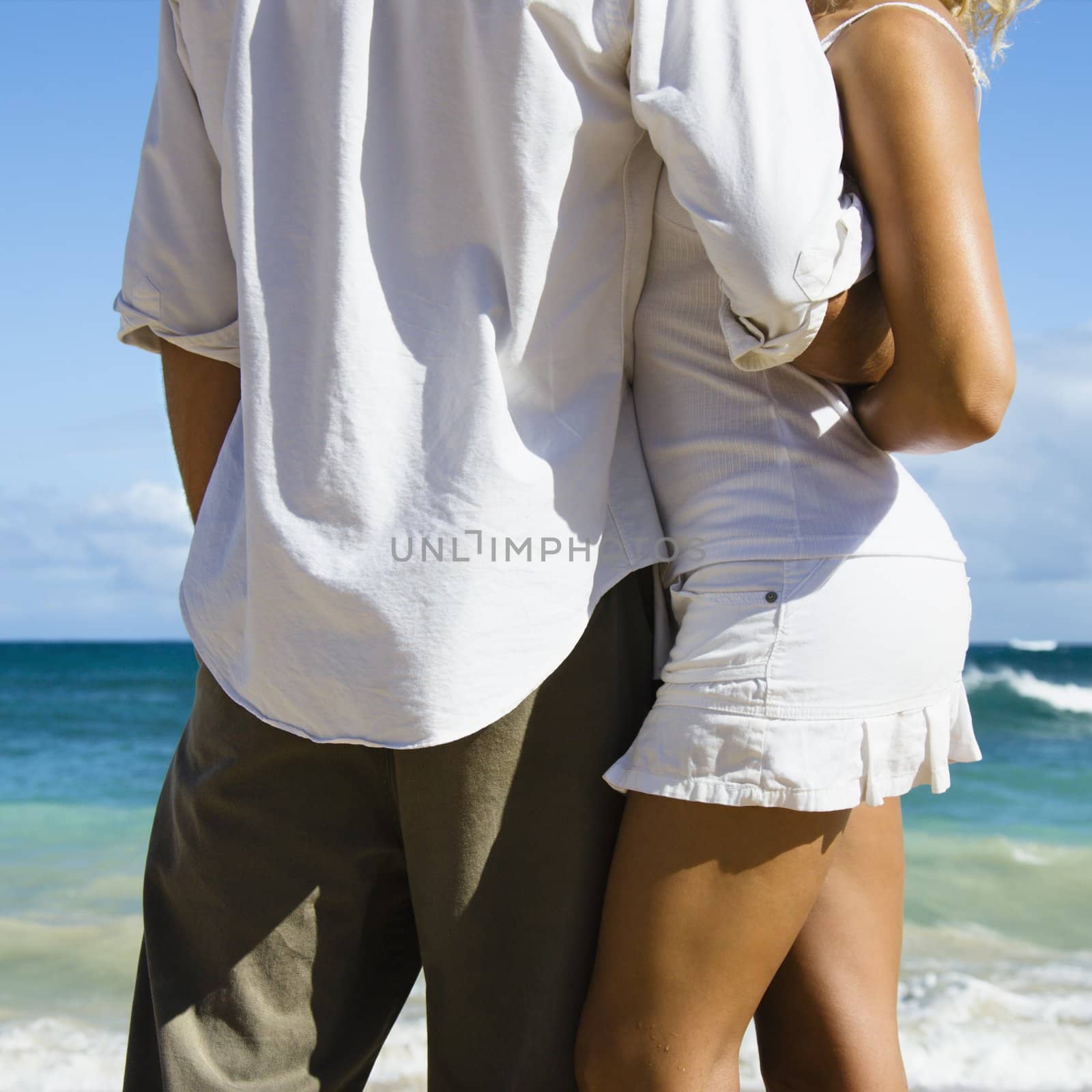 Attractive couple in embrace on Maui, Hawaii beach.