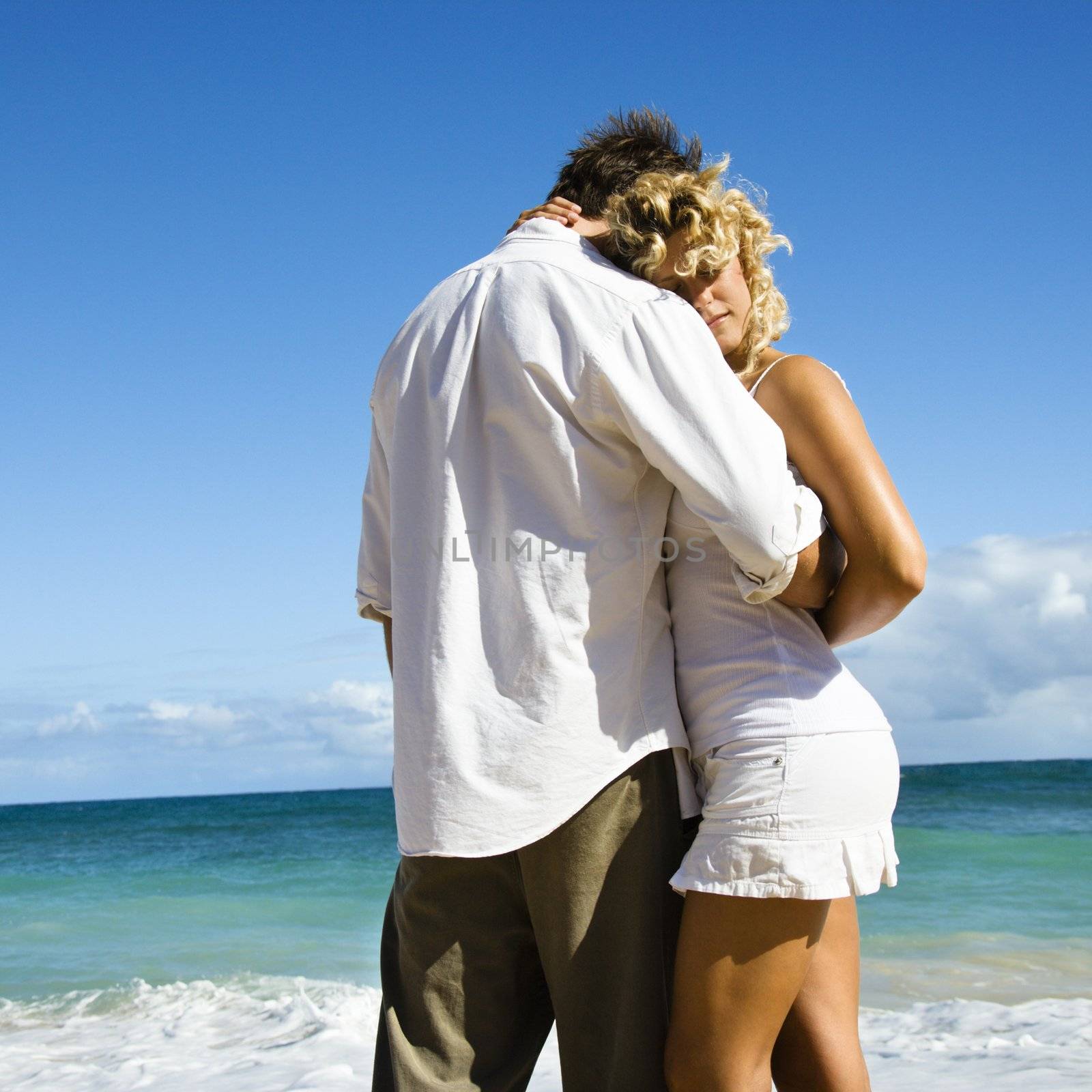 Attractive couple in embrace on Maui, Hawaii beach.