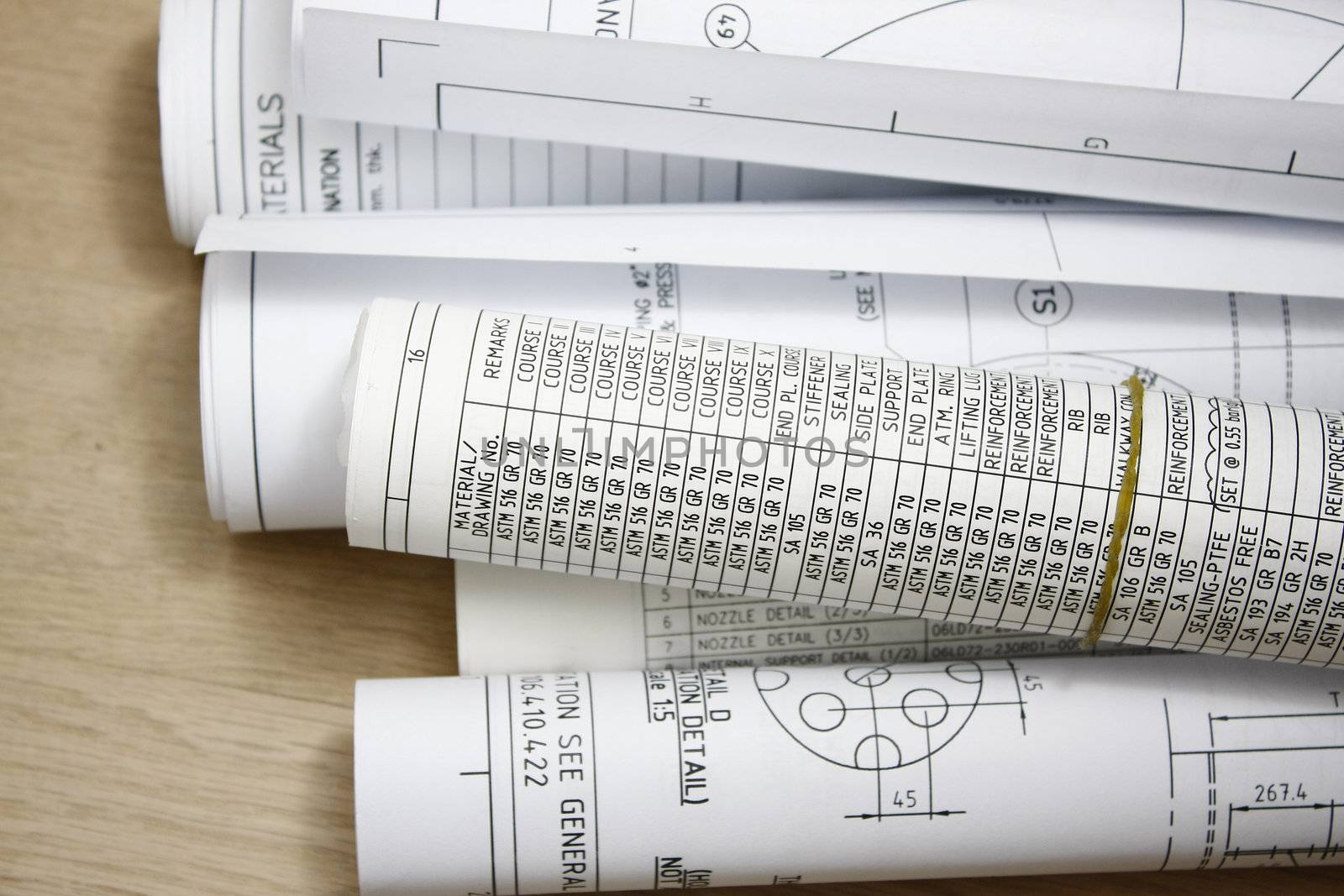 Rolls of engineering drawing blueprints in tile background