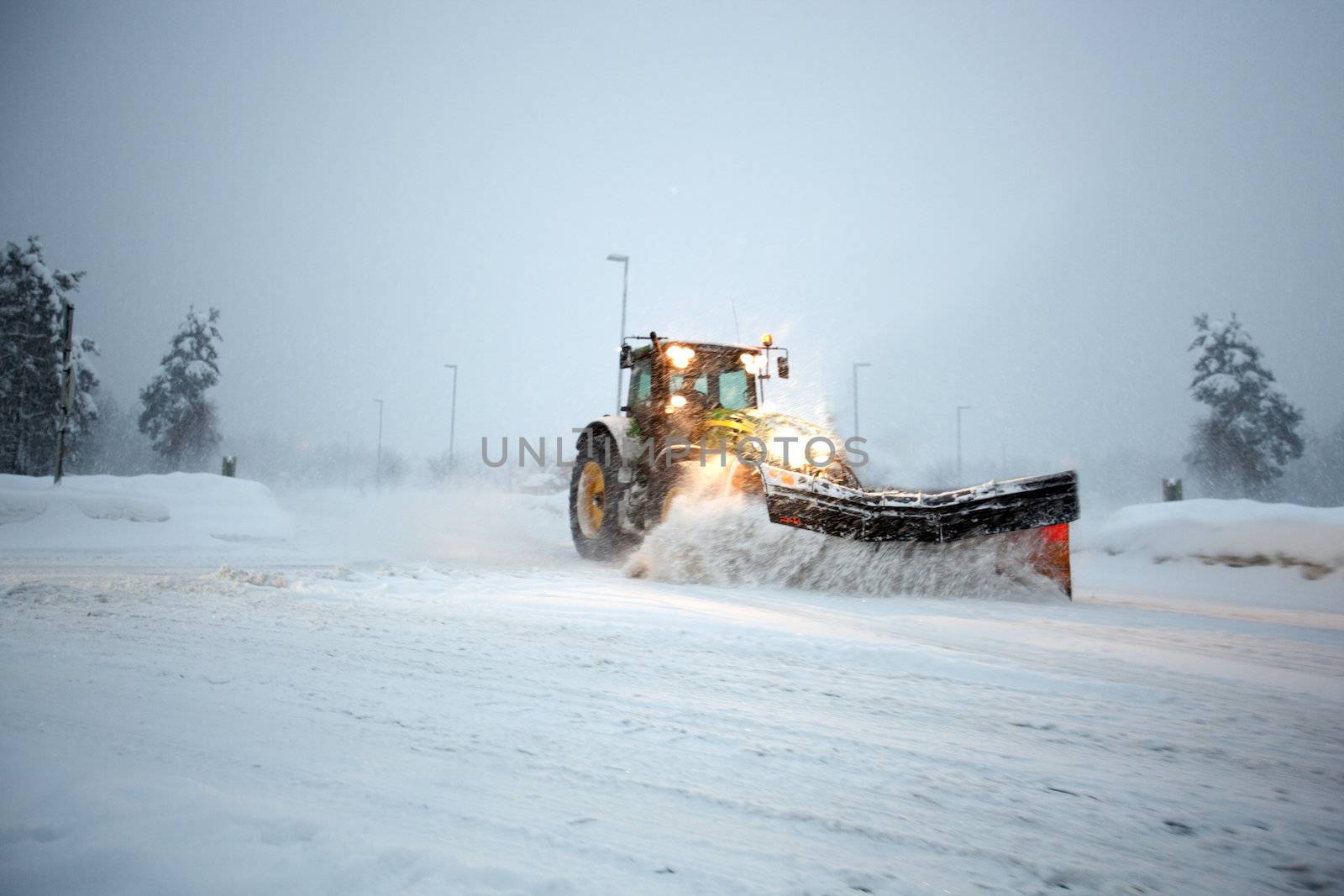 A snow plow clearing a road in winter