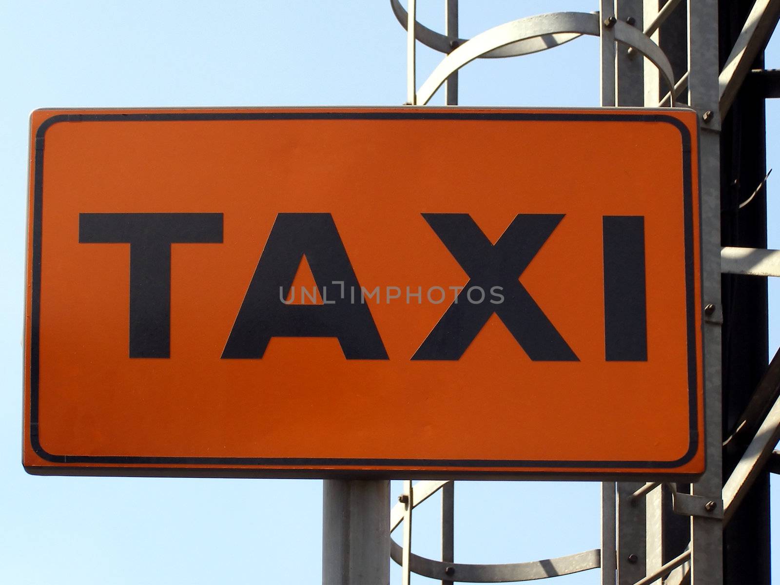 Orange Taxi sign over blue sky