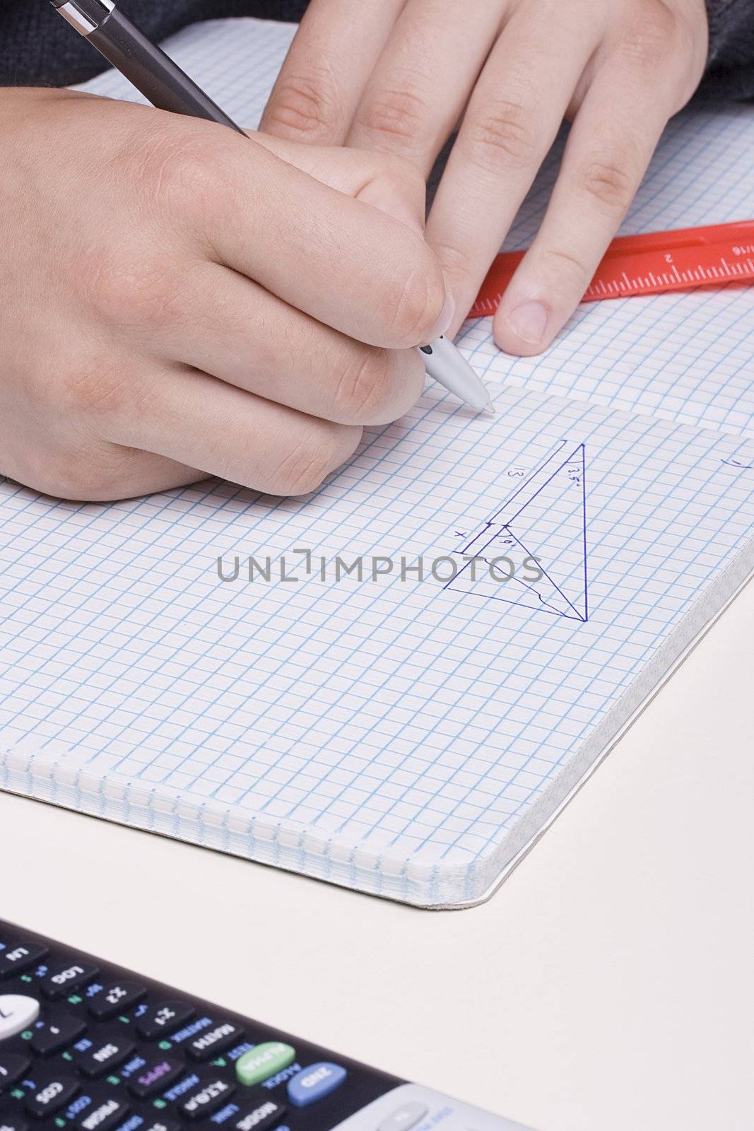 Student doing geometry problem in a notebook.