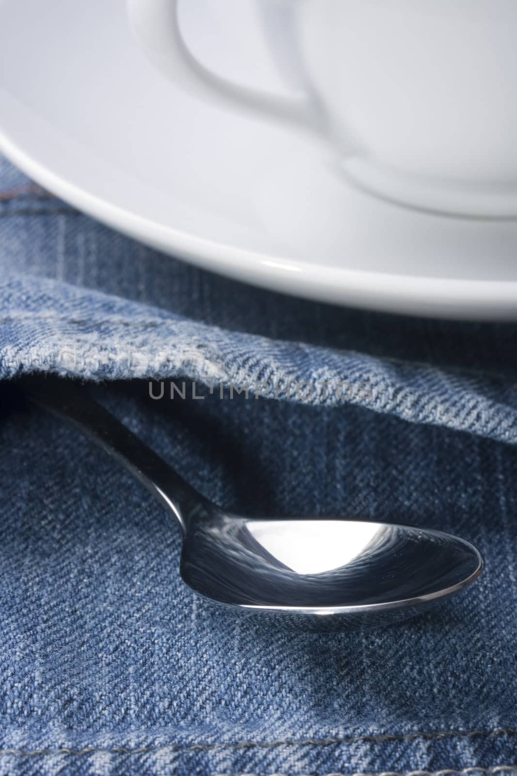 Spoon in a pocket of dark blue jeans trousers.