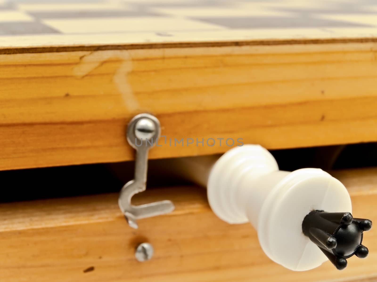 white king in wooden chess home with hook