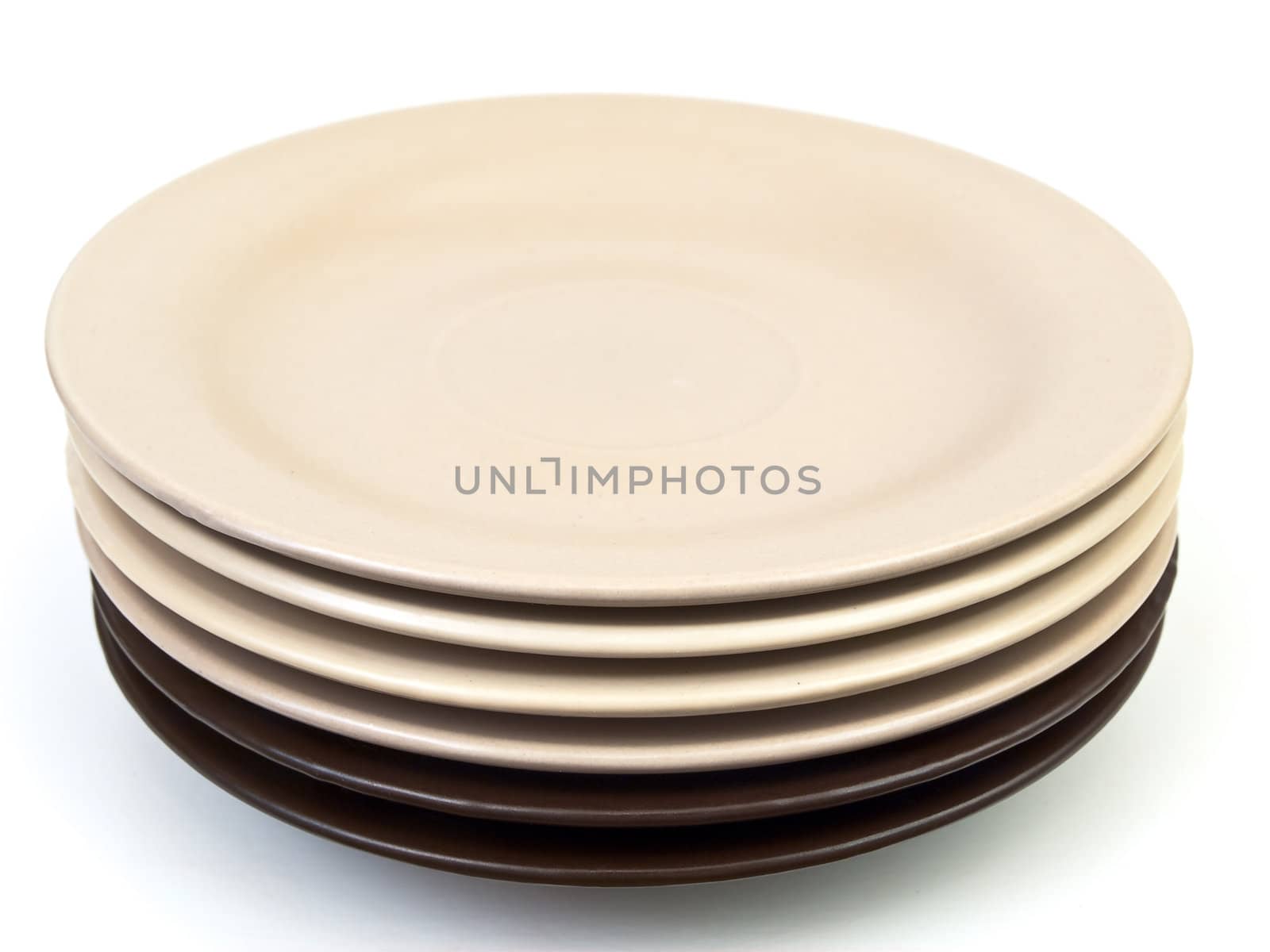 beige and brown saucers against the white background 
