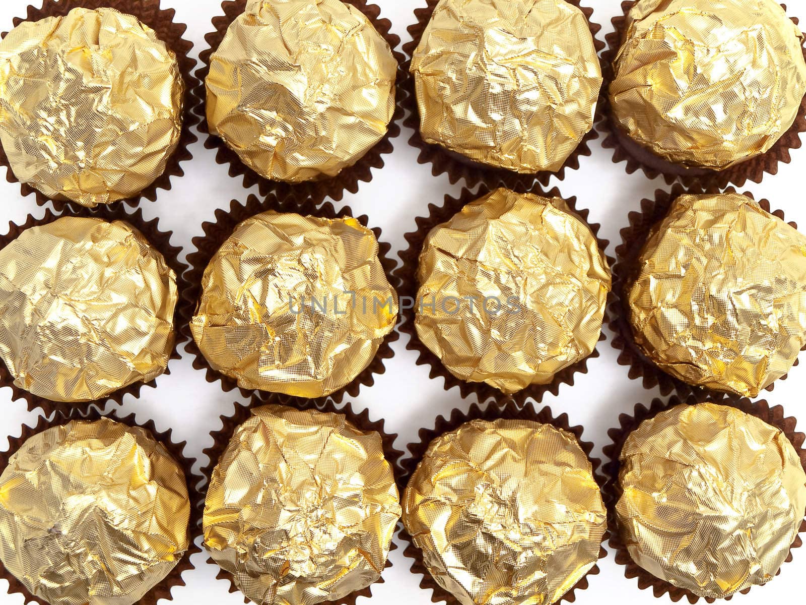 rows of candies in gold paper over the white background