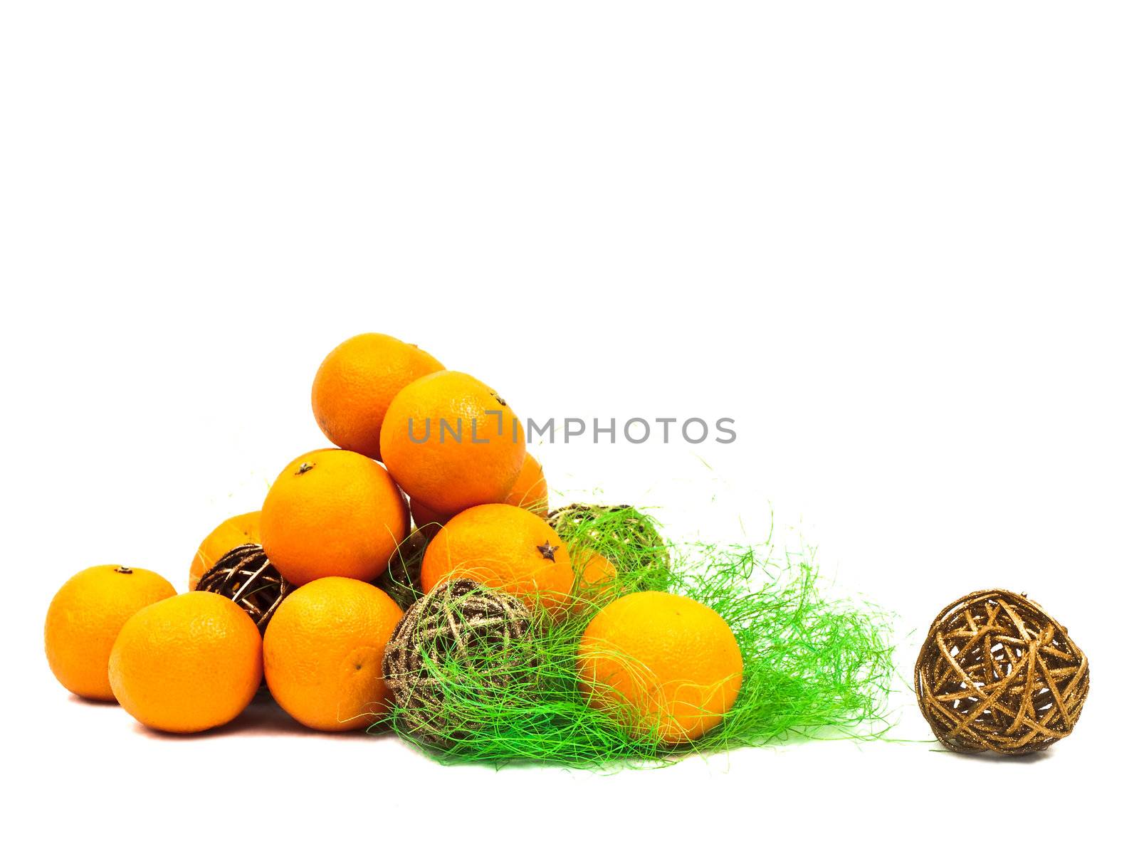 mandarines and golden balls with green against the white background