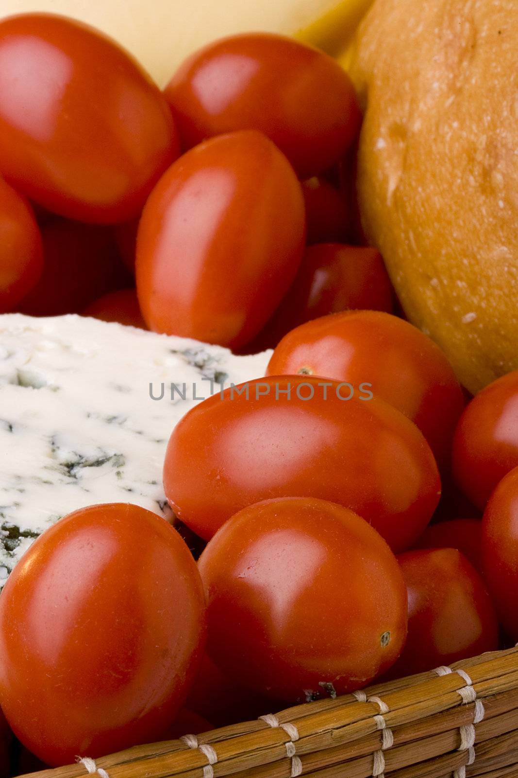 Slice of the Danish blue cheese with a mould among tomatoes.