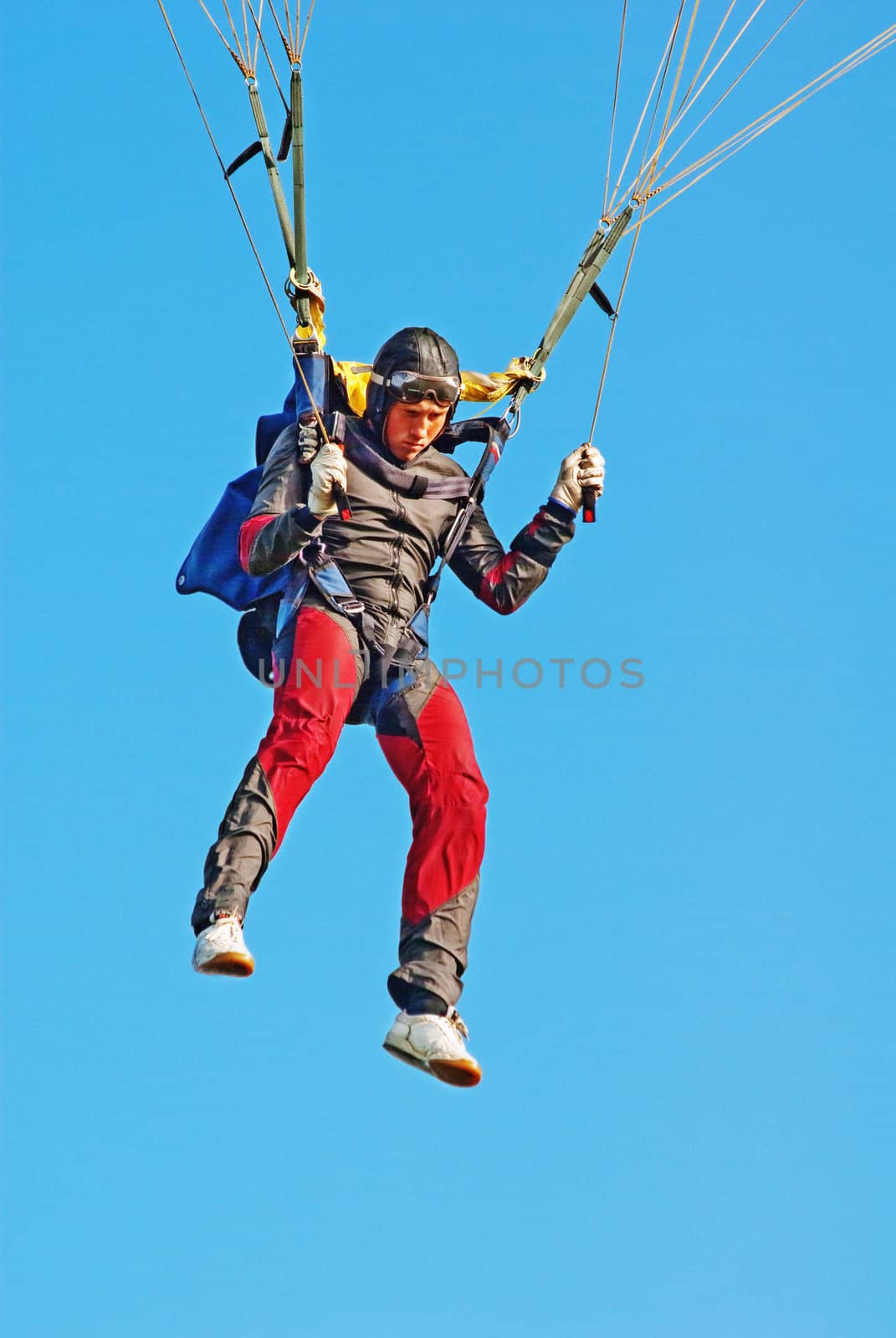 The young parachutist in air operates a parachute