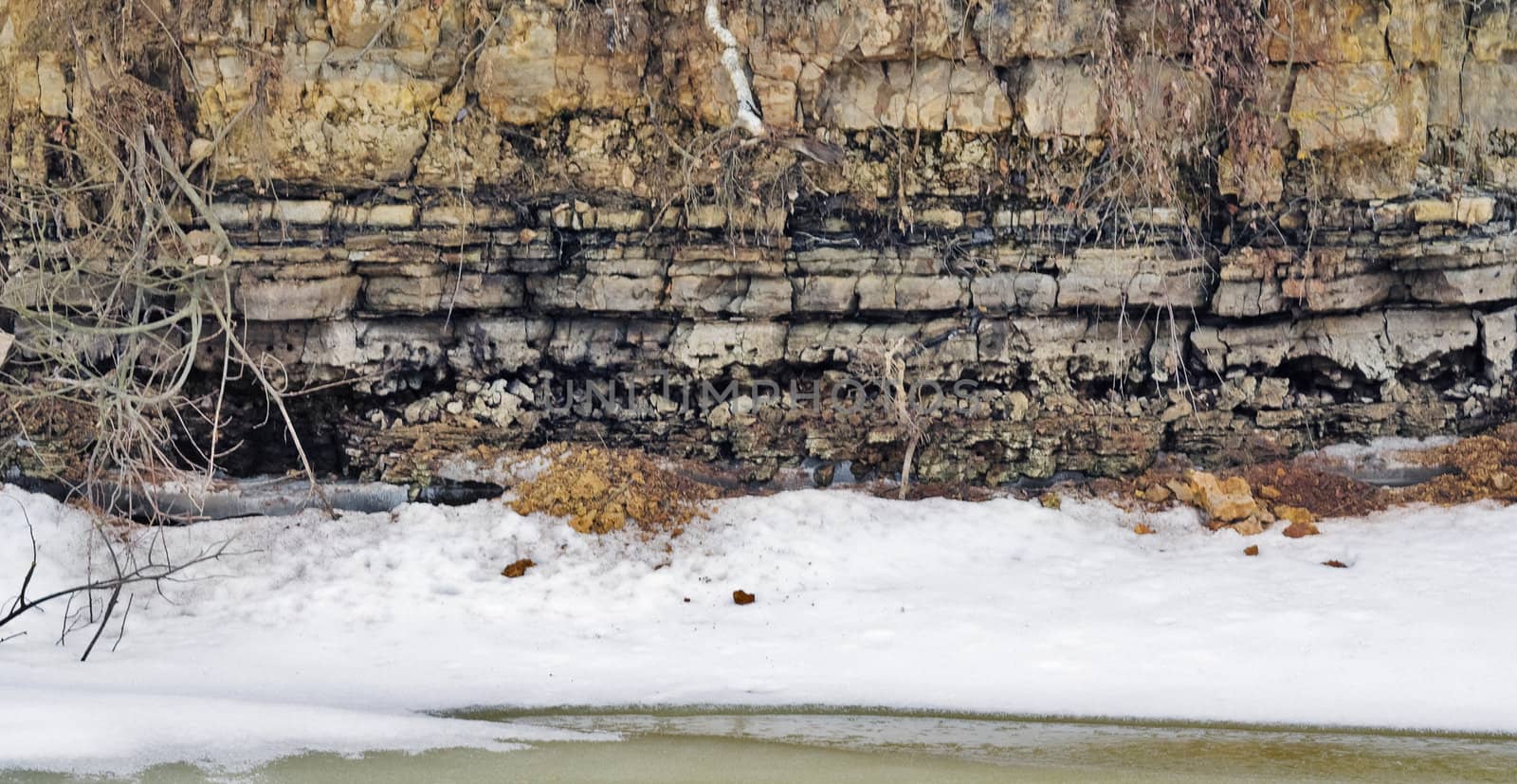 Layers of a dolomitic rock on the frozen lake coast