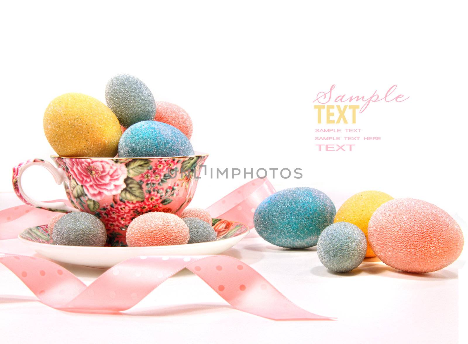 Brightly colored eggs in tea cup on white
