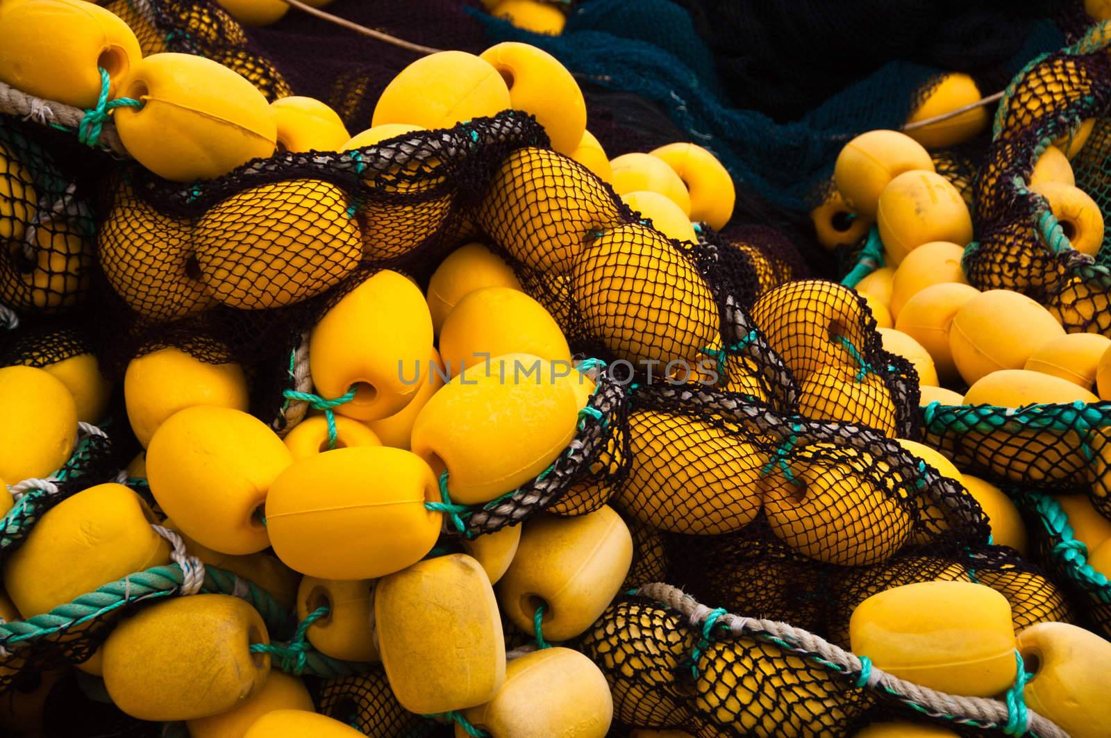 Closeup on fishing net with yellow floaters stored on fisher boat during the day