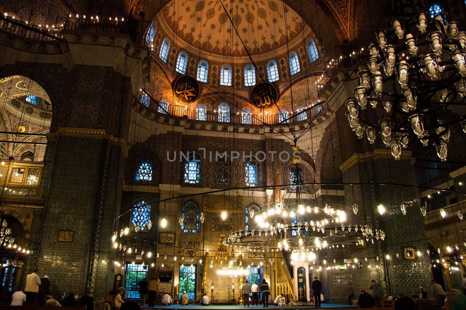 Moslems performing their prayer in the gorgeous Yeni Camii mosque in Istanbul, Turkey