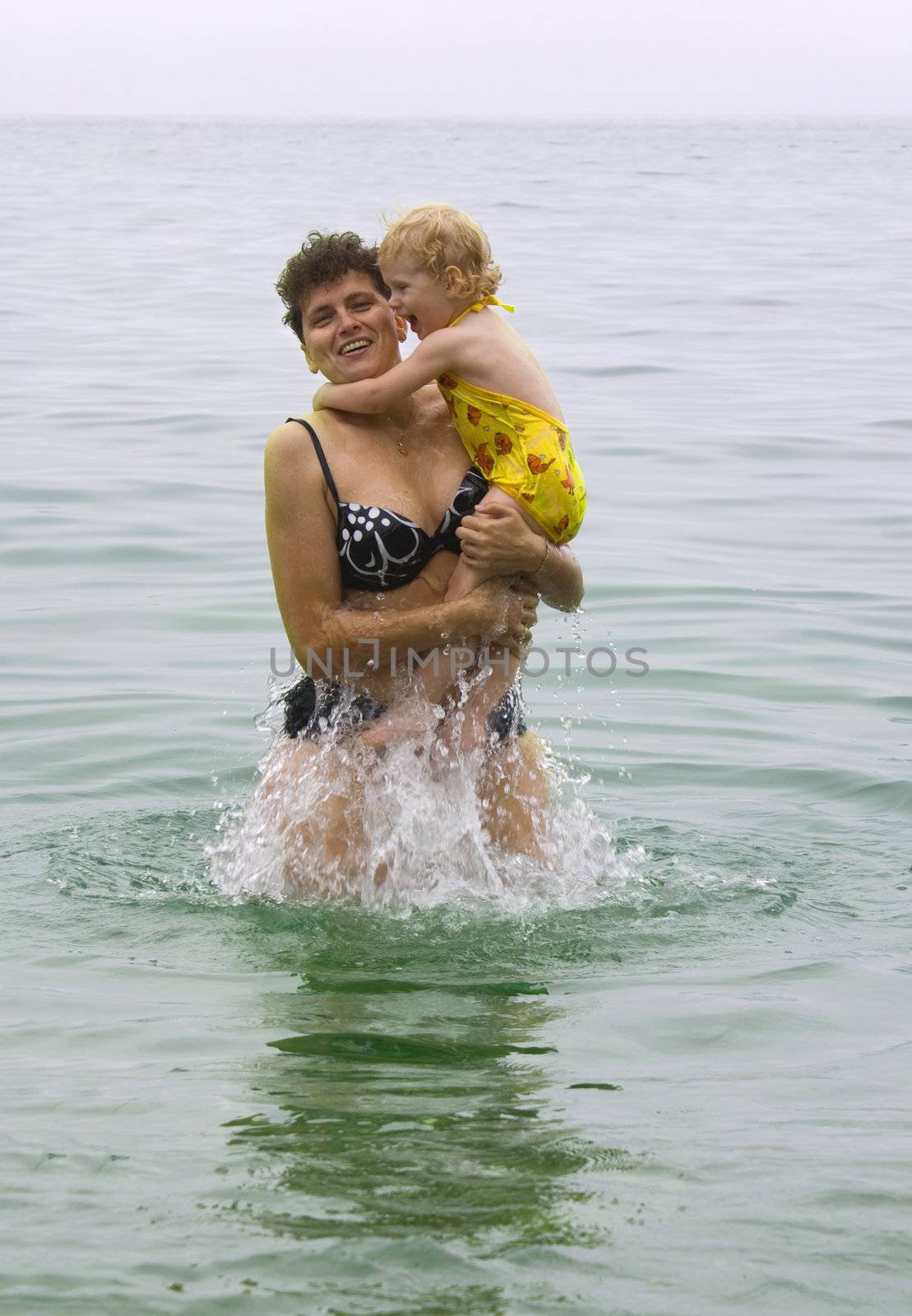 woman with little daughter swimming in the sea