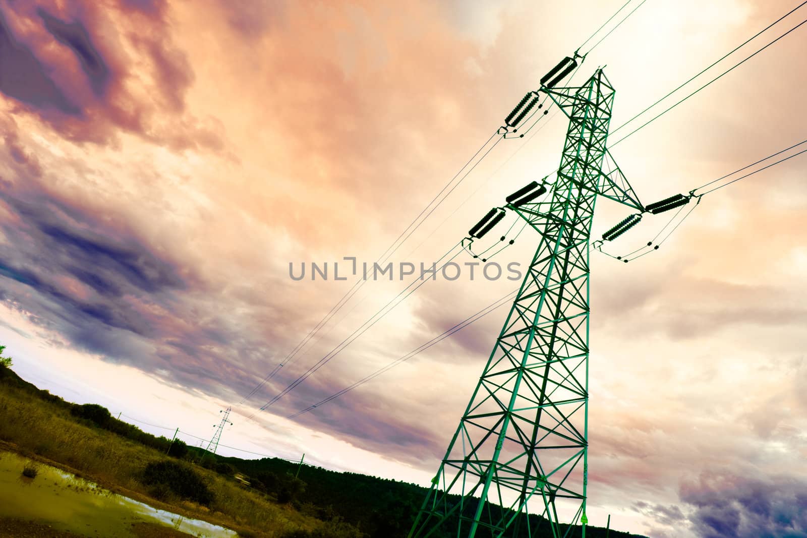 High voltage tower backlit with idyllic sky