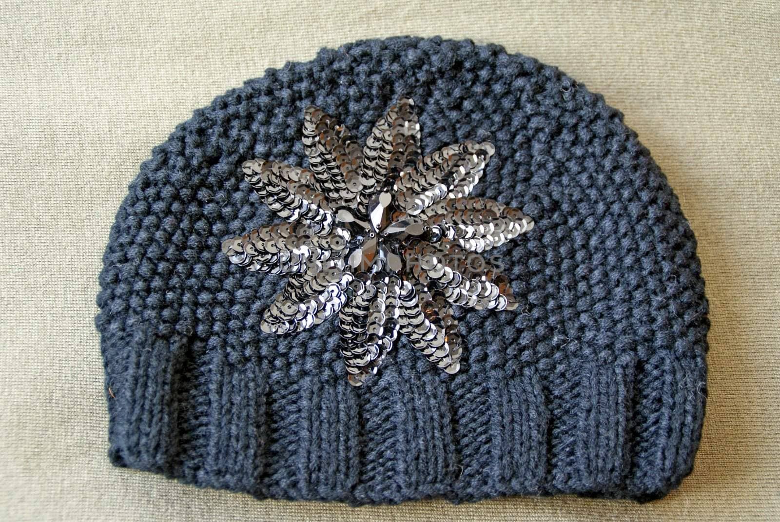 A dark grey knit beanie hat with sequin decoration.