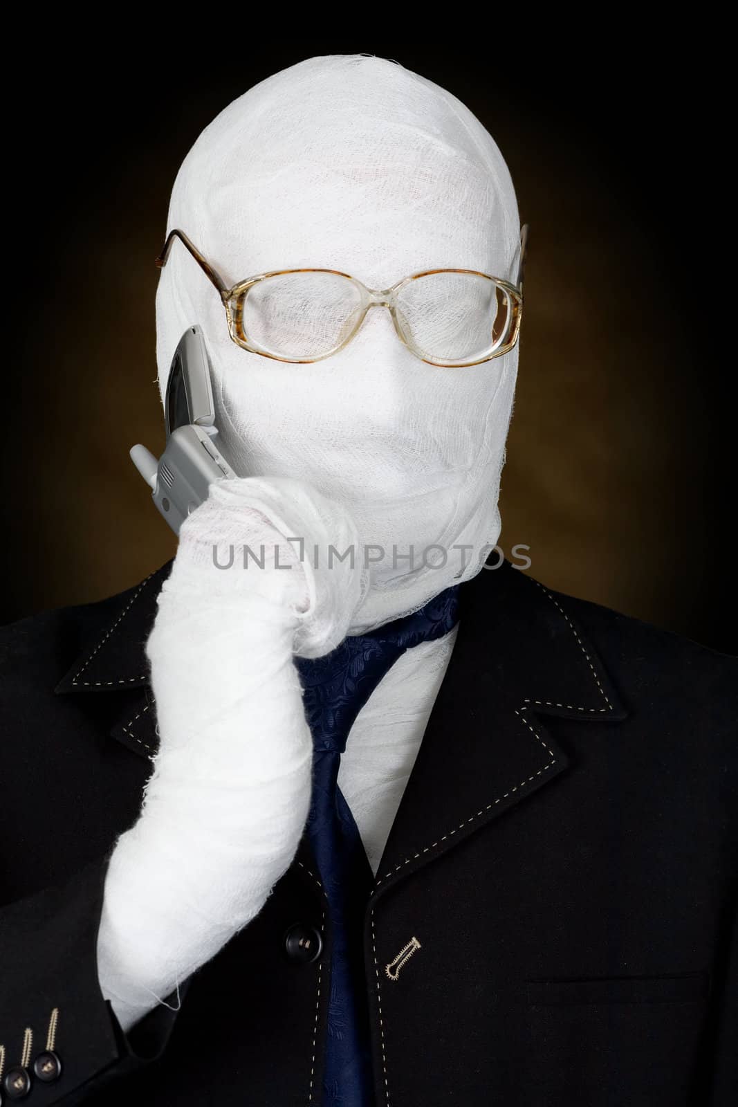 Mummy-businessman talking on telephone on the black background