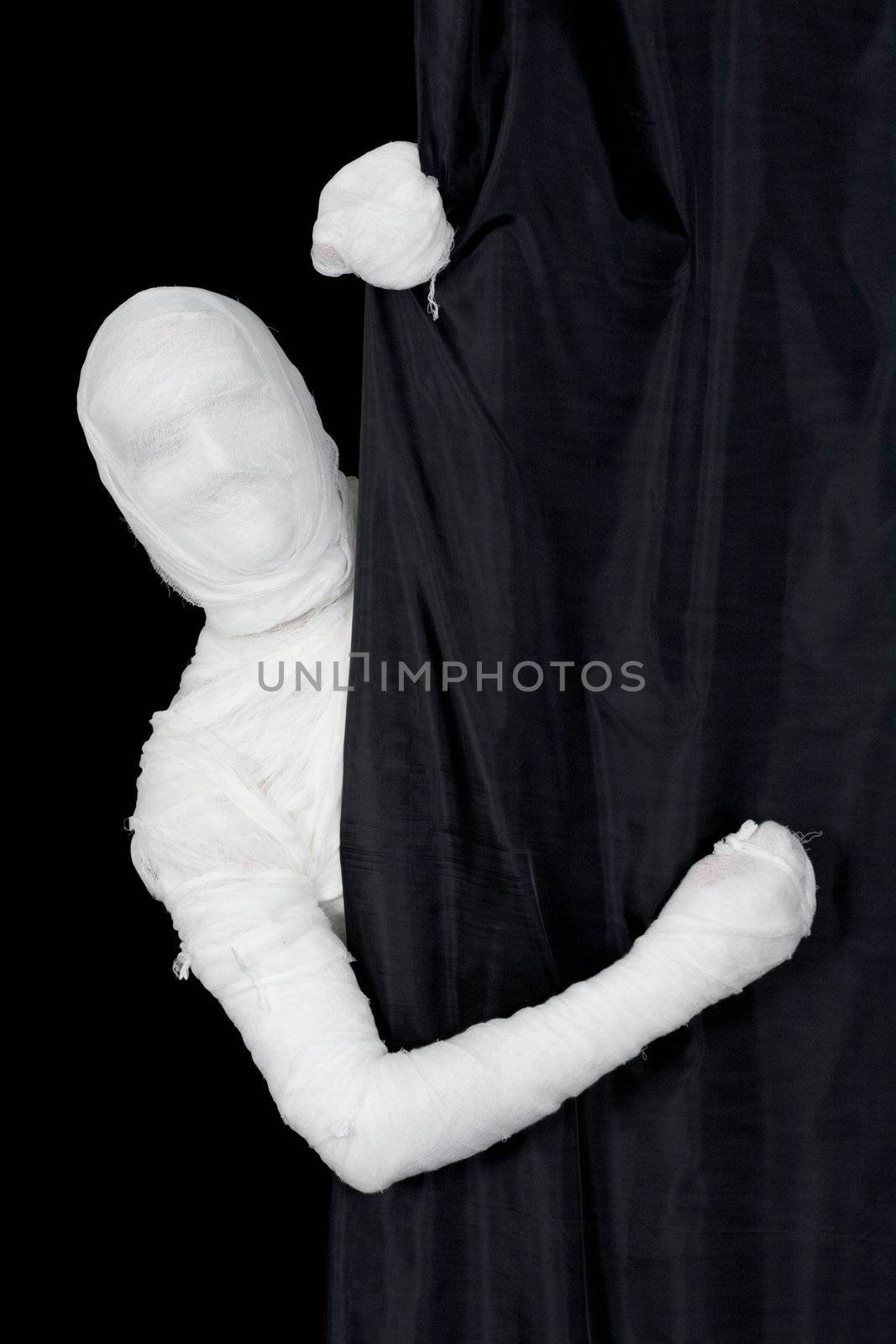 Man in bandage looking from behind of curtain