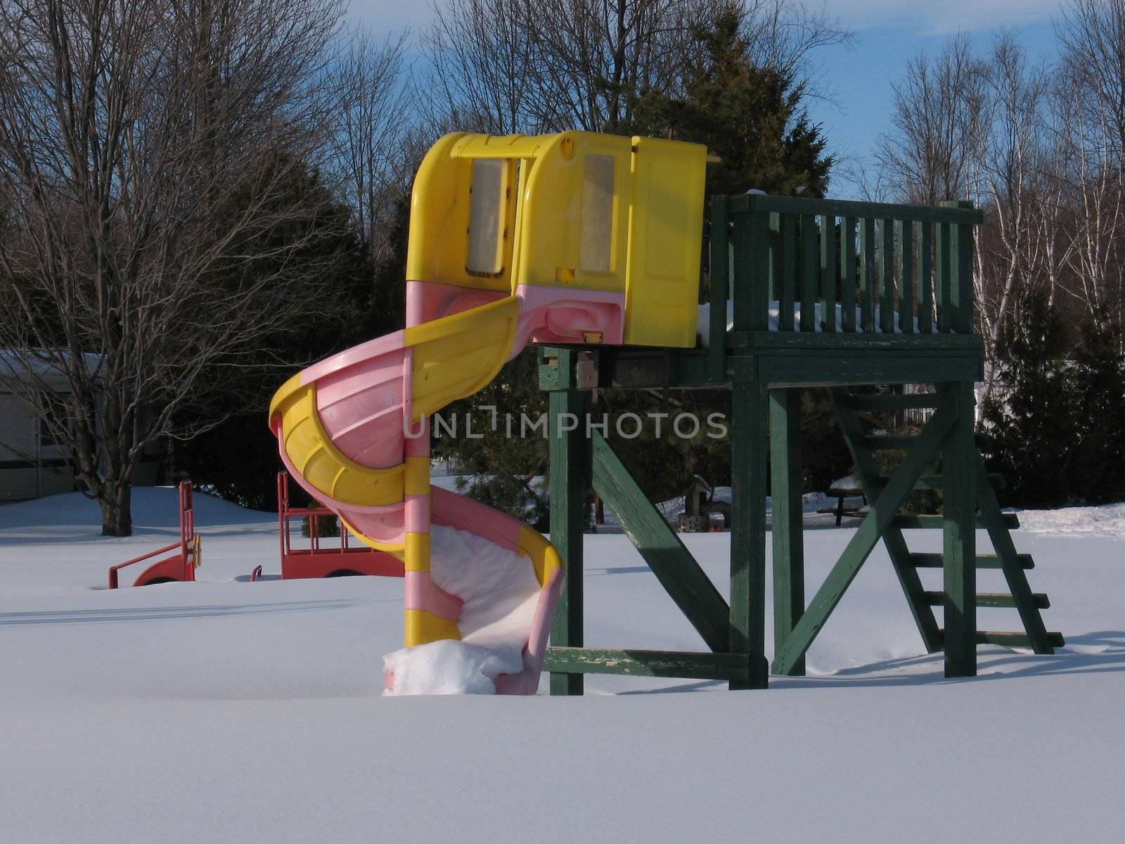 A slide in a playground at the height of winter.