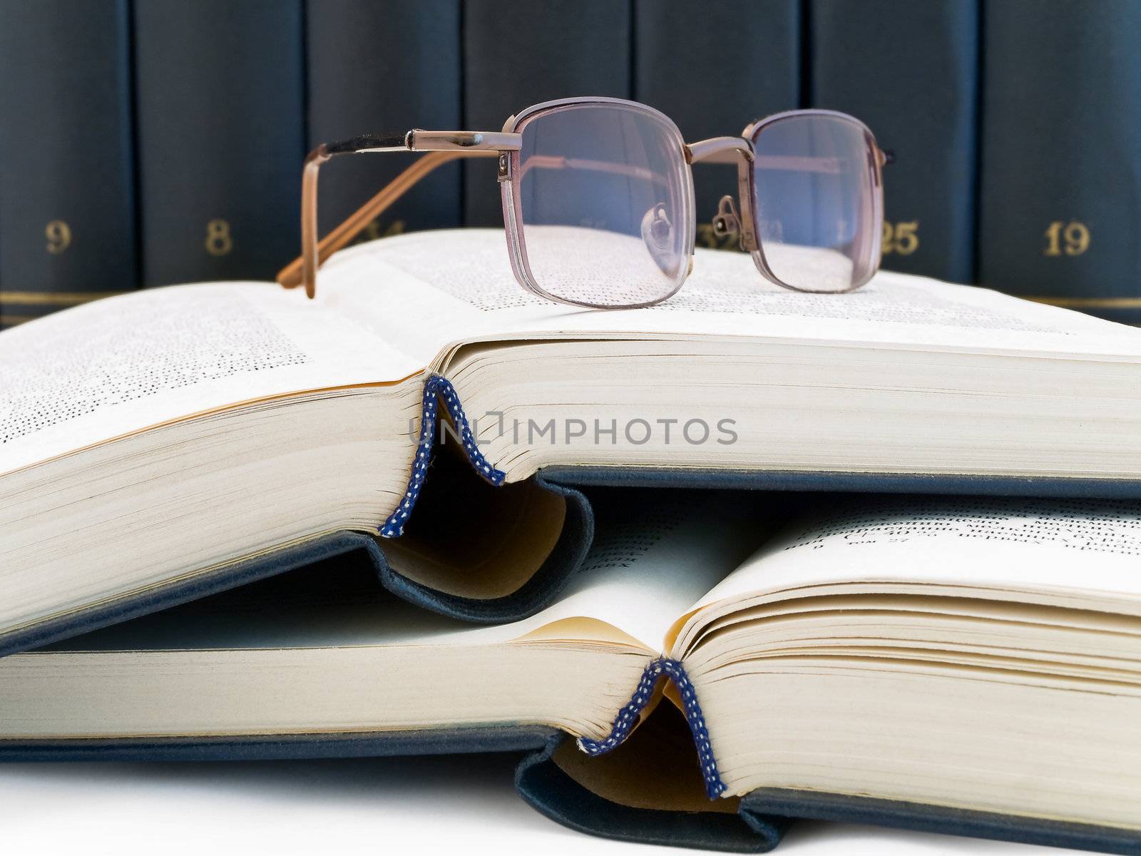 books and glasses against the book shelf