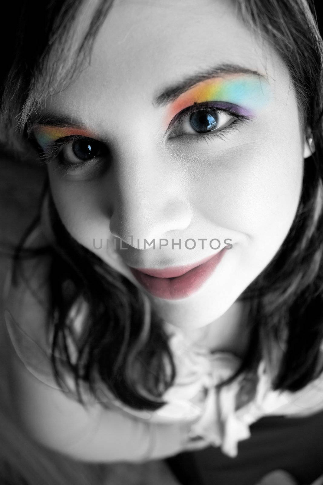 Portrait of a beautiful young womans face close up with rainbow eyeshadow makeup.  Shallow depth of field.