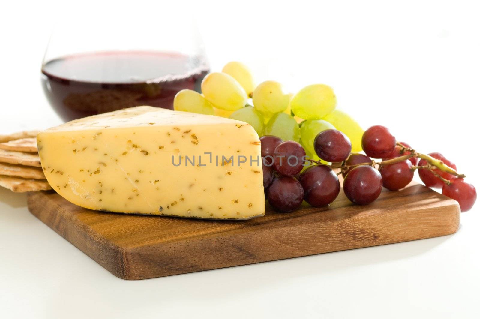 Wedge of spiced  cheese served with wine and grapes.