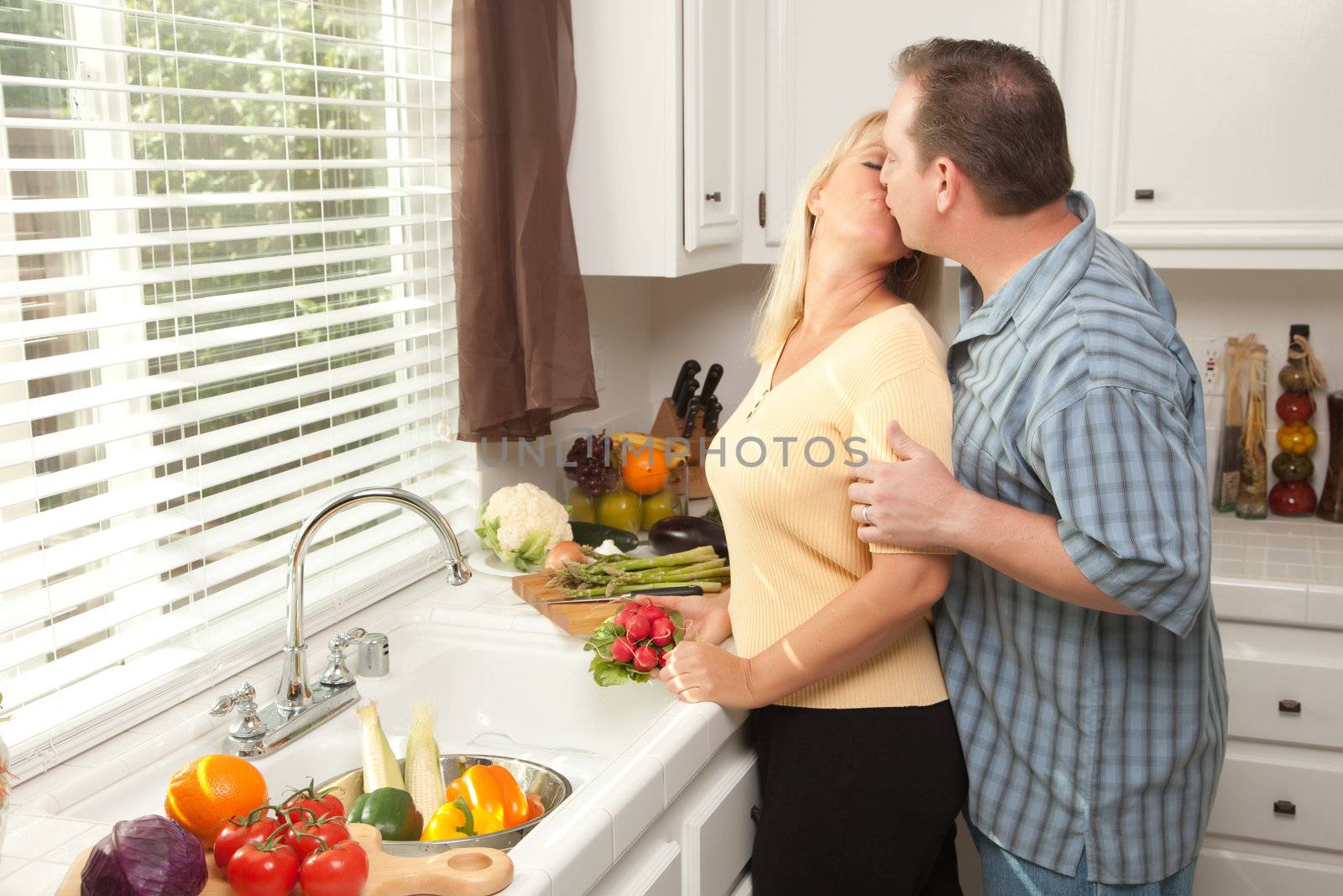 Happy Couple Enjoying An Eveing Preparing Food in the Kitchen.