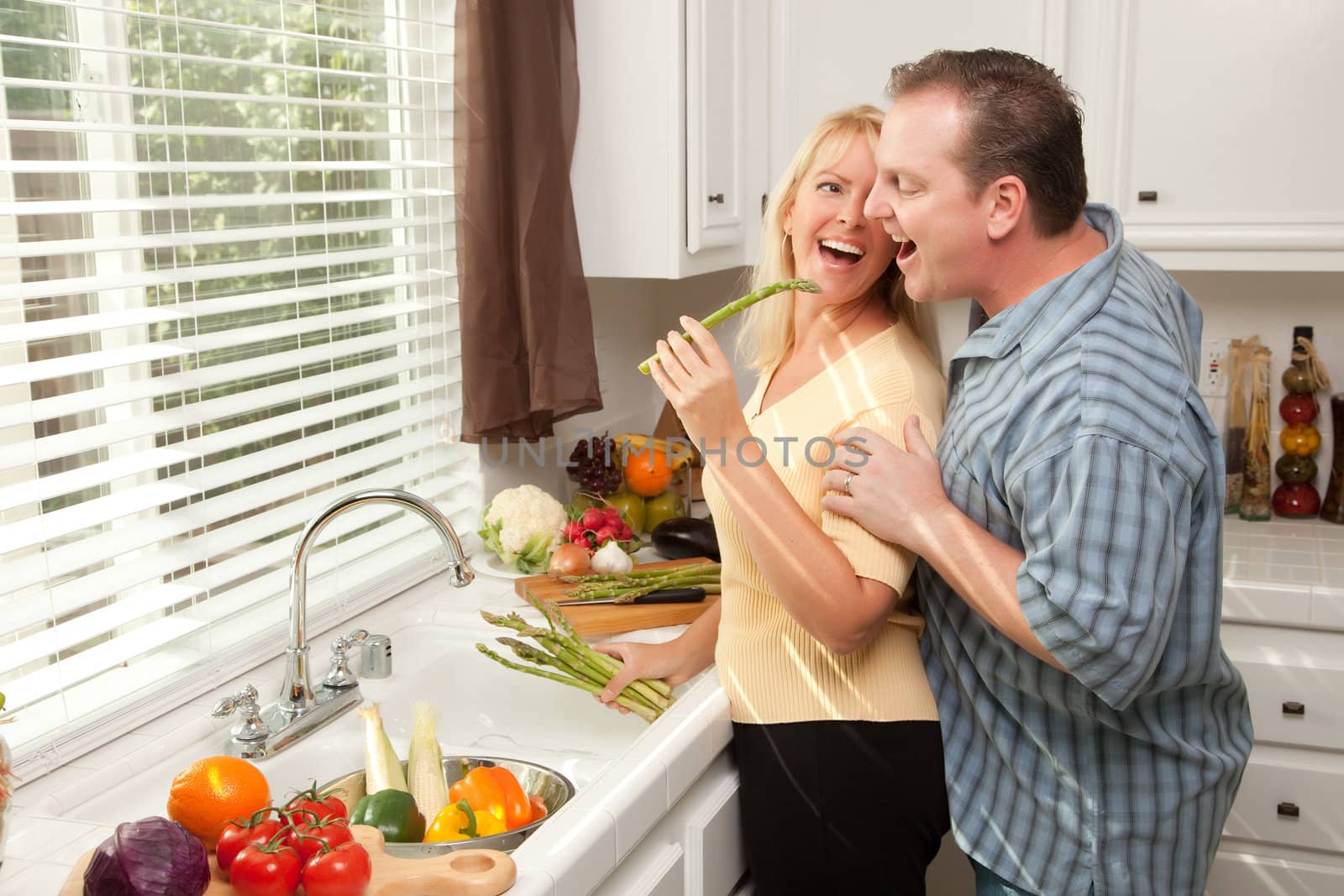 Happy Couple Enjoying An Eveing Preparing Food in the Kitchen.