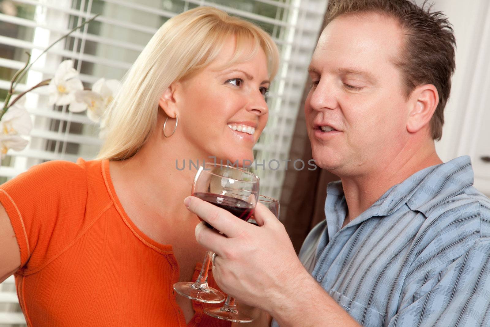 Happy Couple Enjoying a Glass of Wine the Kitchen.