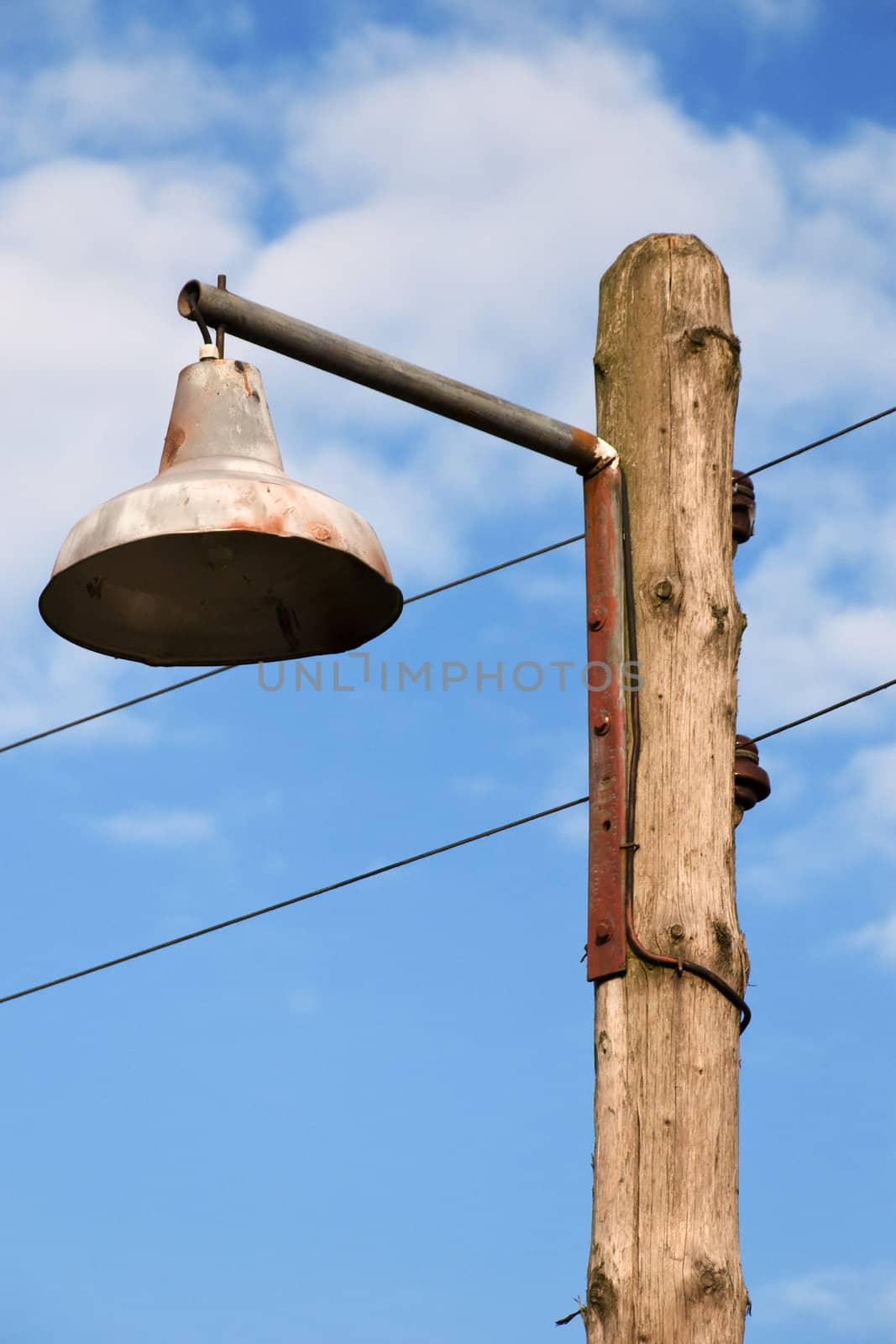 Old Lantern on a Wooden Pole Against a Blue Sky
