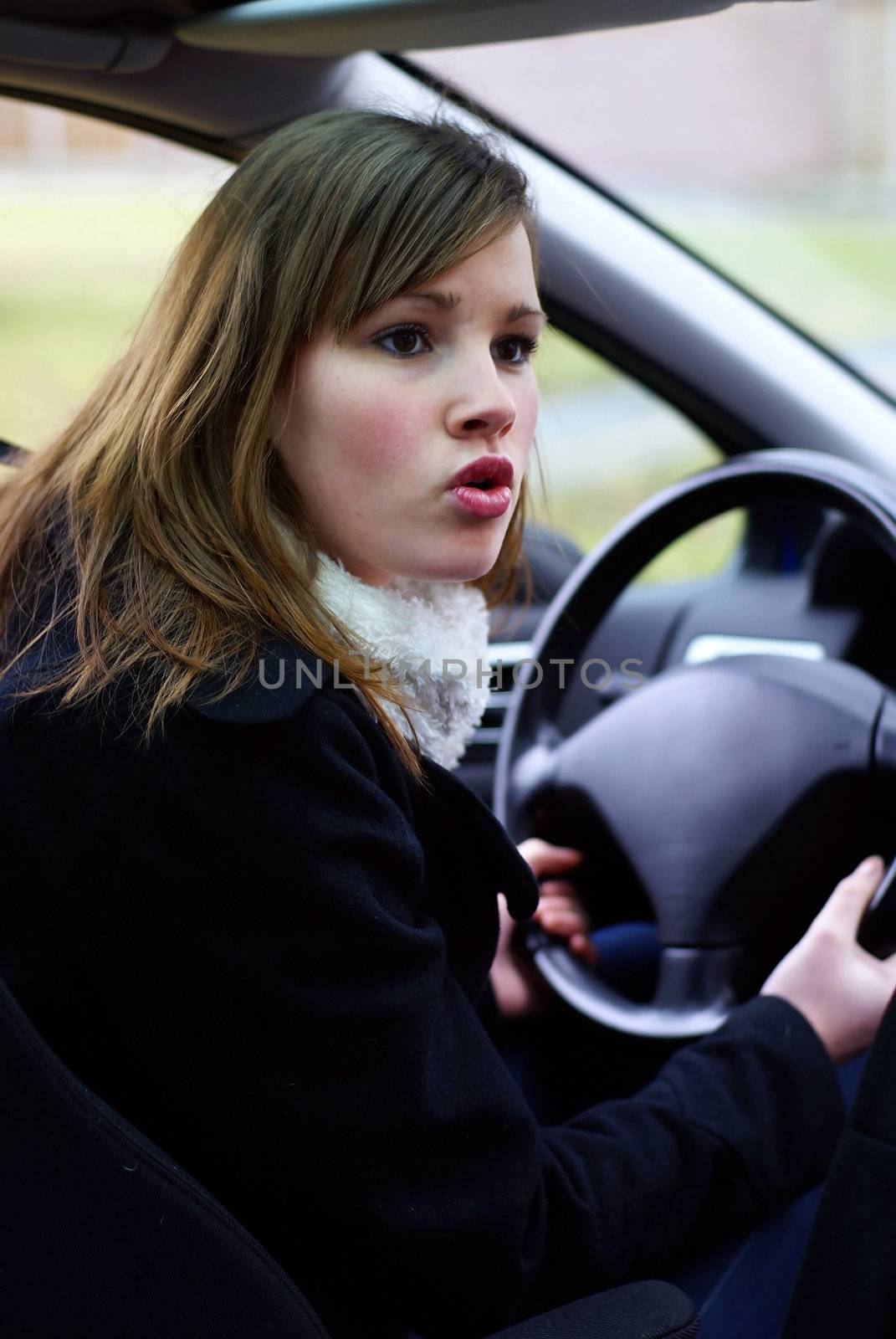 Teen girl mad behind the wheel.