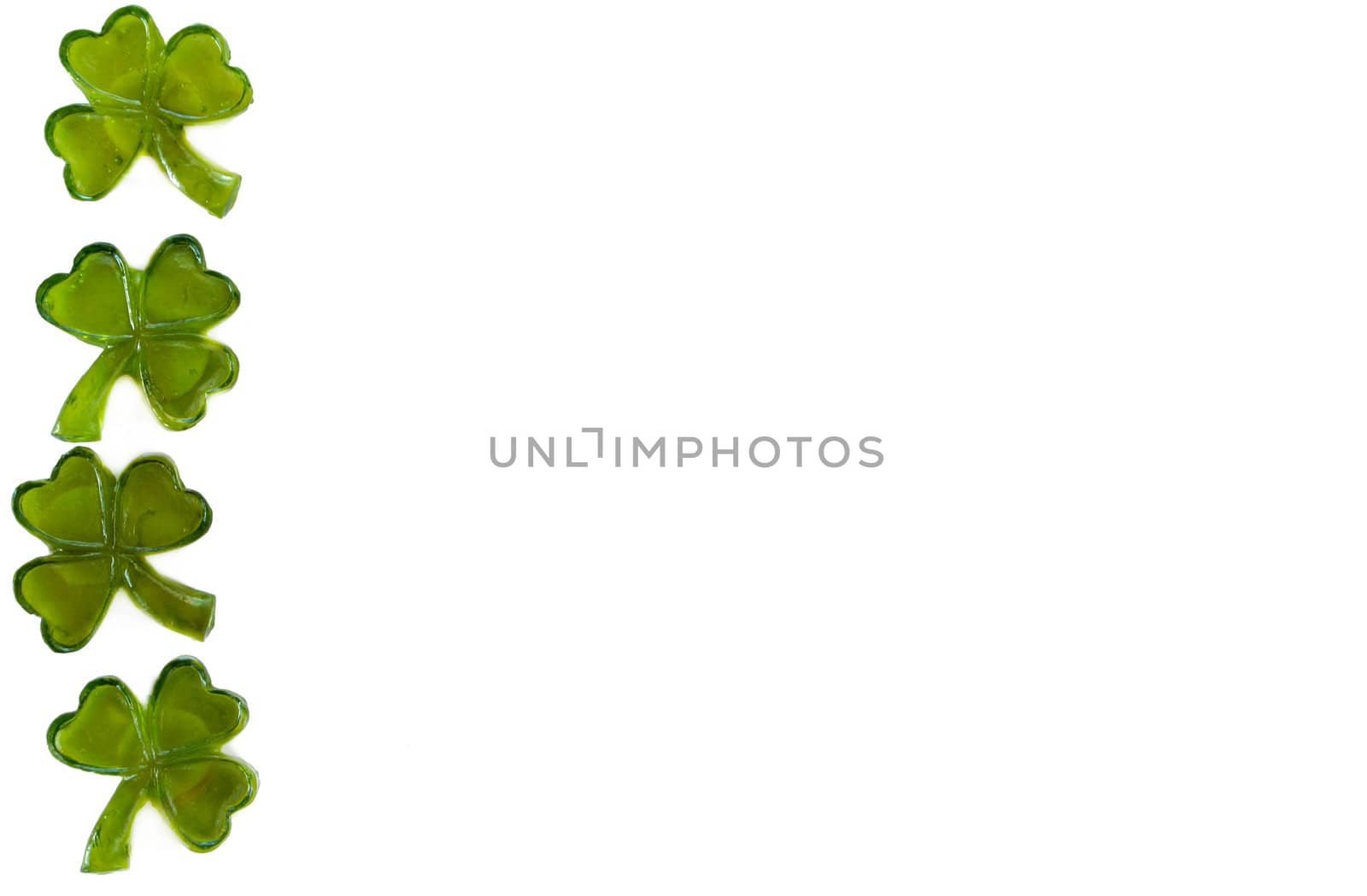 Four leaf clovers making a boarder on a white background.