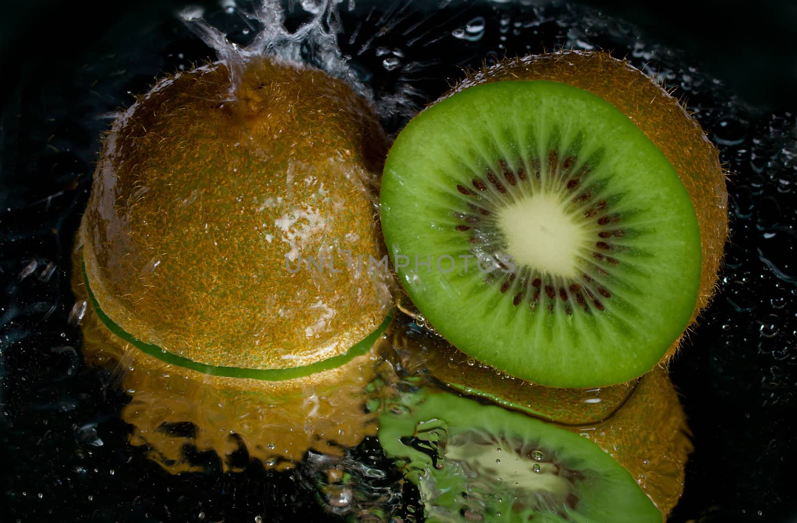 kiwi dousing with water, with reflection, on black background