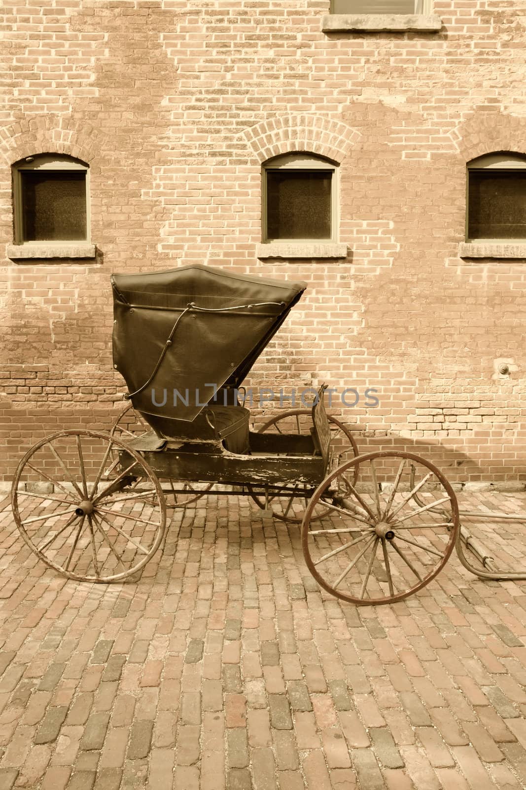 An old horse-drawn carriage done in sepia.
