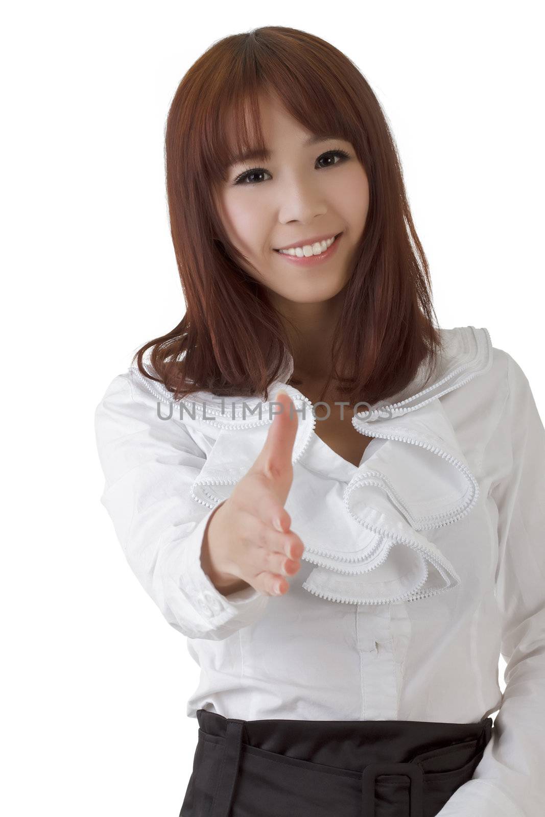 Pretty business woman greeting you and shaking hand with smile.