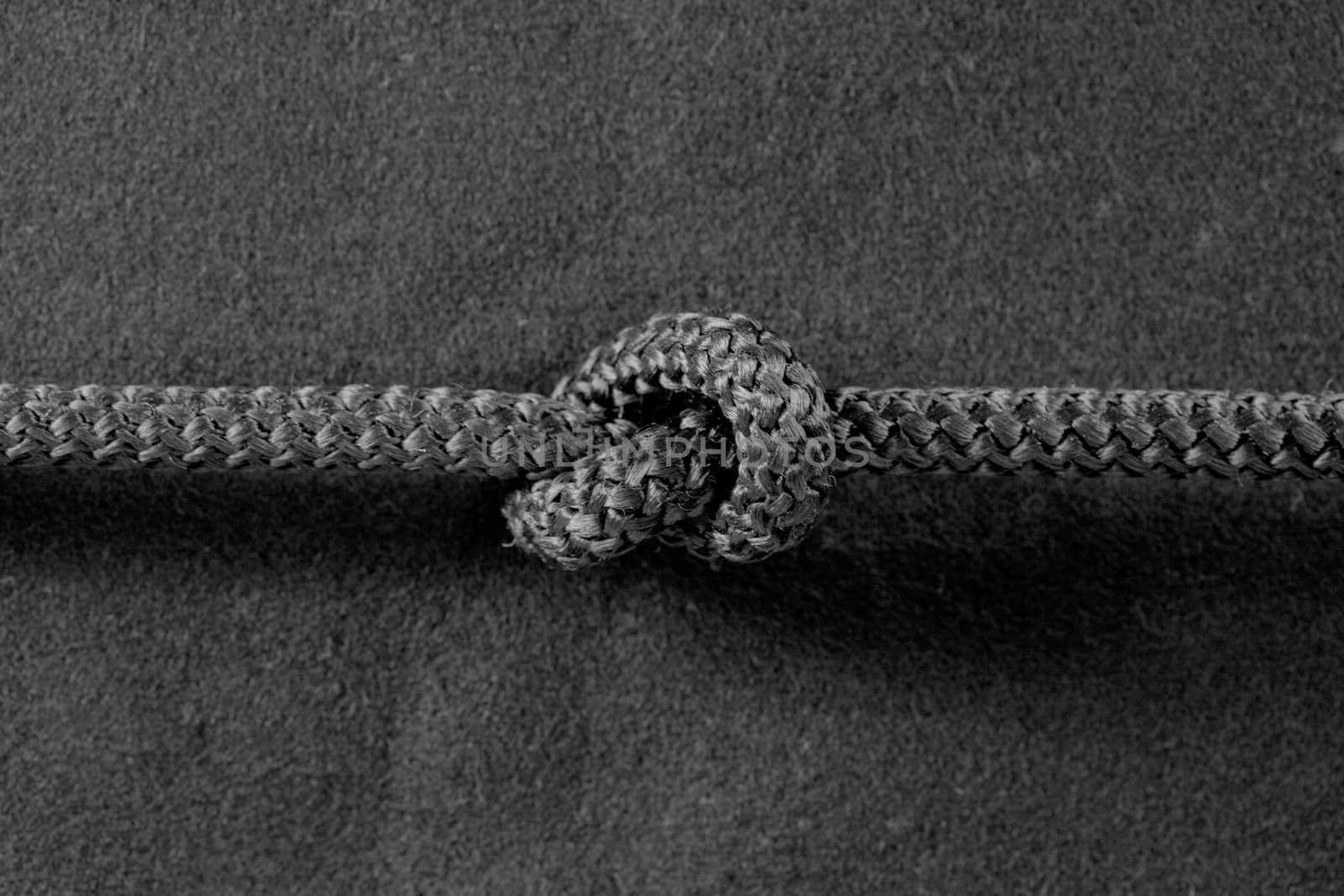 Knot on cord on the textile black background