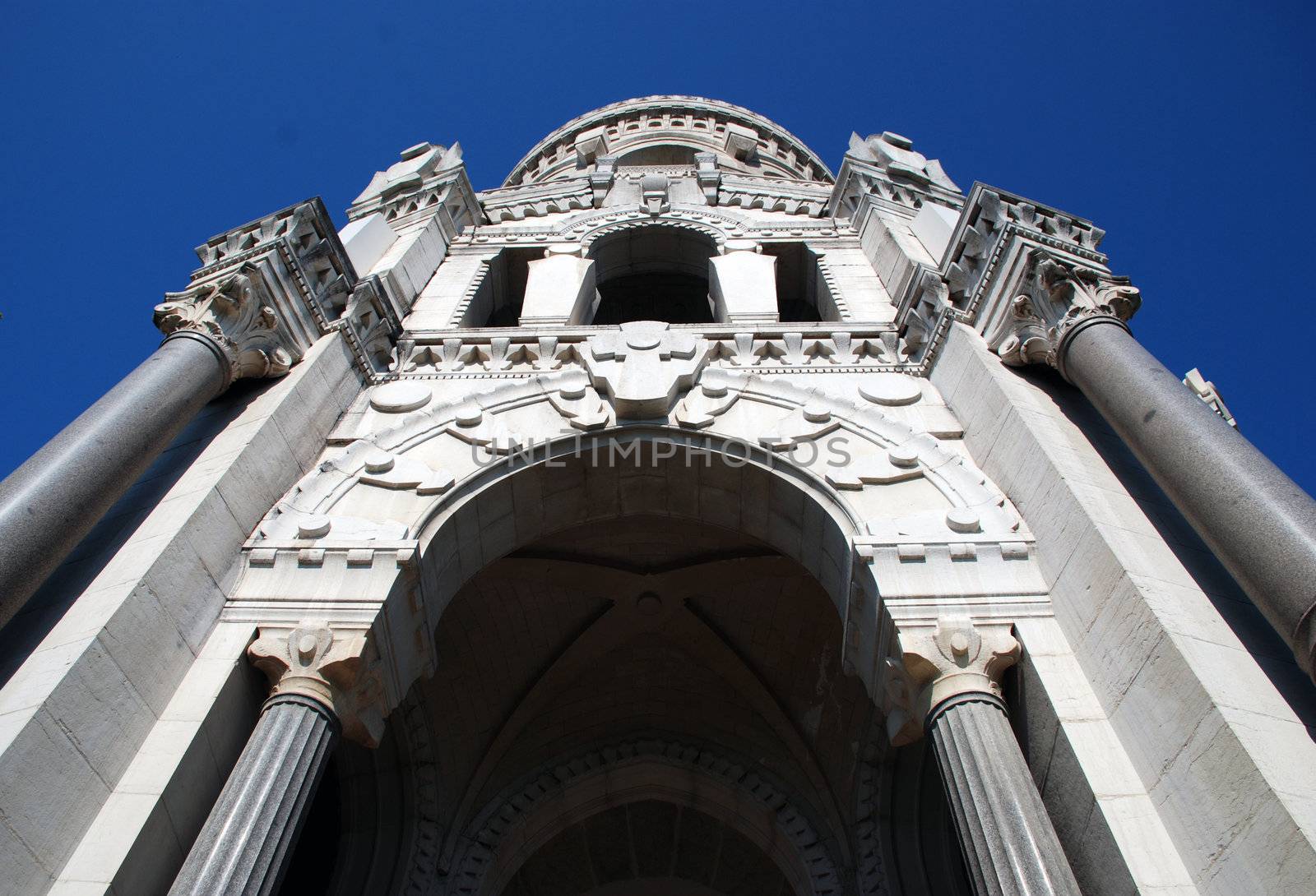 We can see this Basilic situated in Lyon, a big town in France, from the bottom . It is white,  old religious construction , with very specific detailes, wihth a baroque style.It forms part of the lyon's patrimony. In the background there is the blue sky.