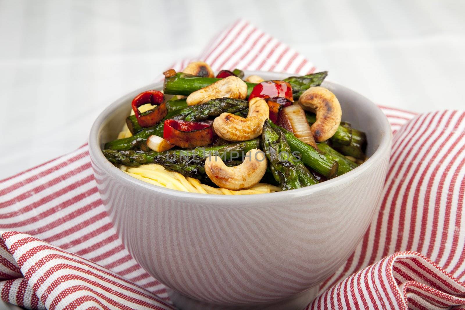 Asparagus and cashew stir fry served over Chinese noodles