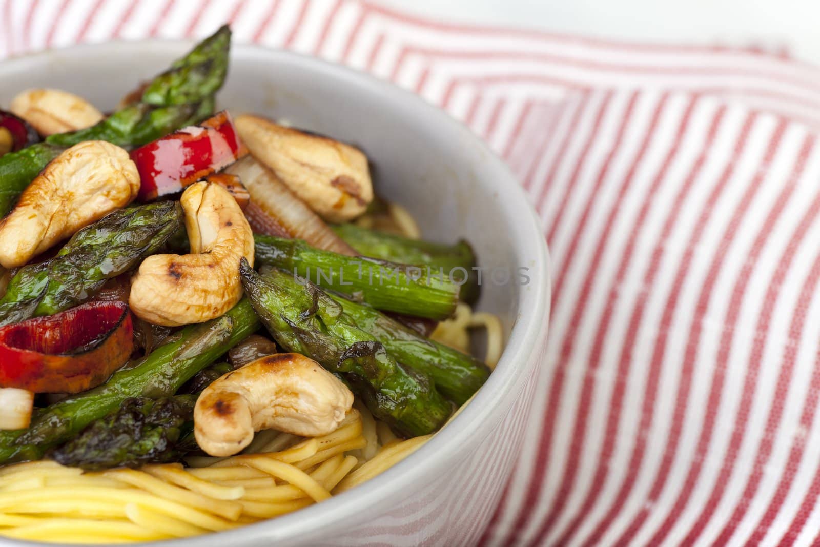 Asparagus and cashew stir fry served over Chinese noodles