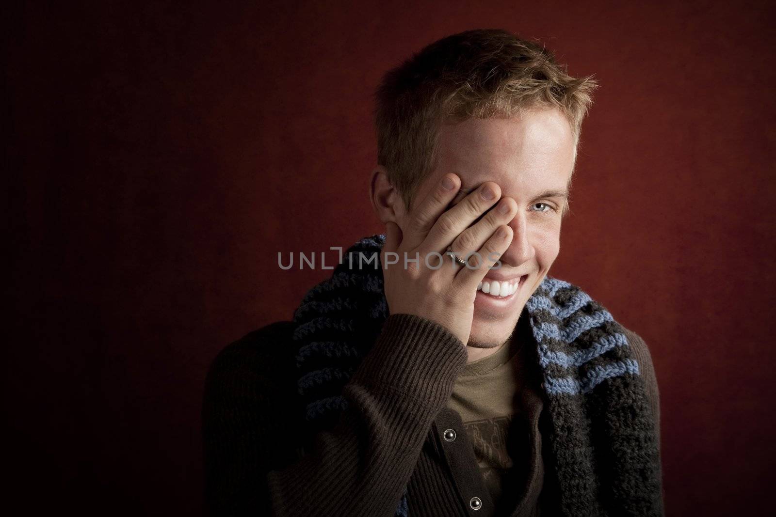 Young man covering face with his hand