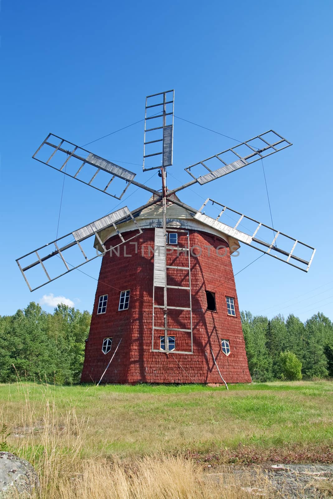 Traditional old wooden windmill painted in red color.