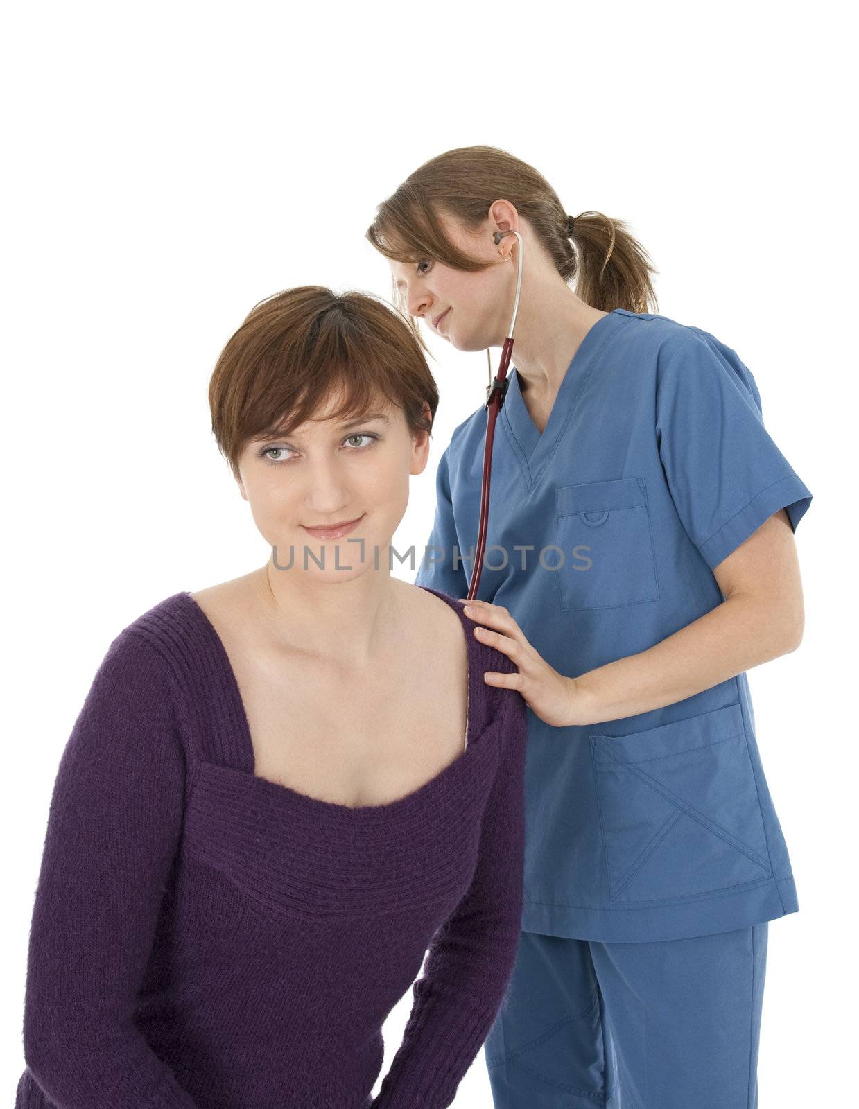 Competent nurse listening to patient's heart with stethoscope.