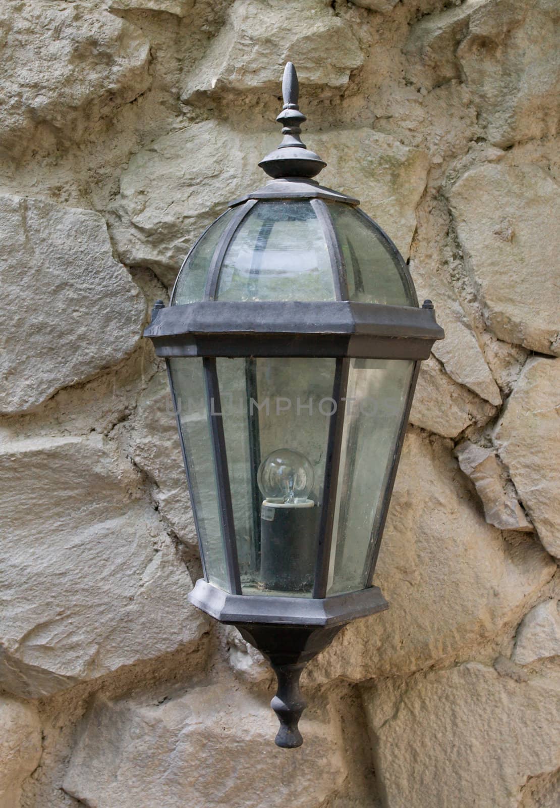 old lantern against stone wall