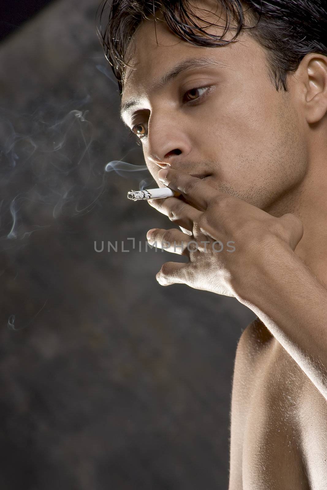 Close-up of an intensively smoking man with heavy smoke