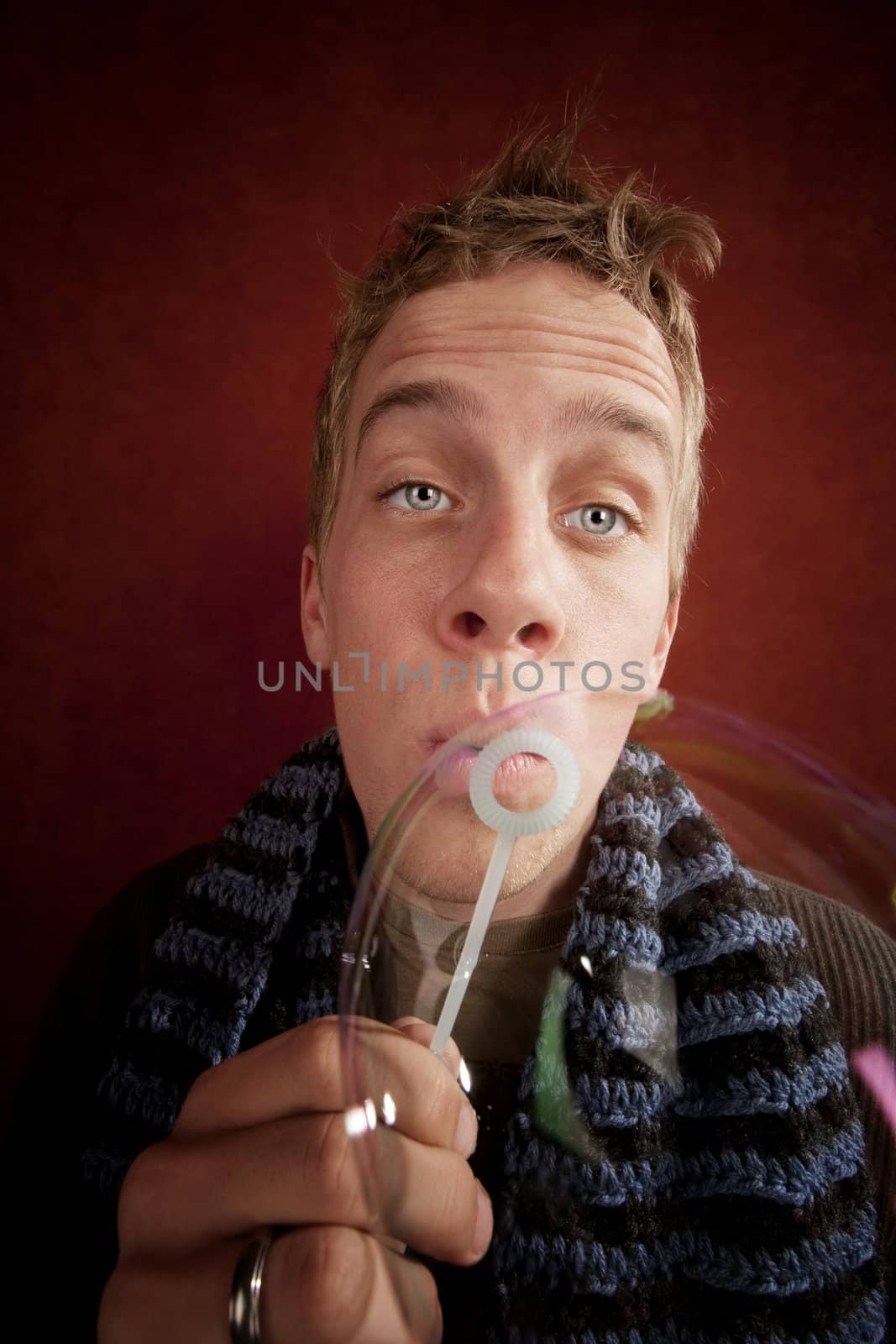 Handsome young blonde man blowing a bubble