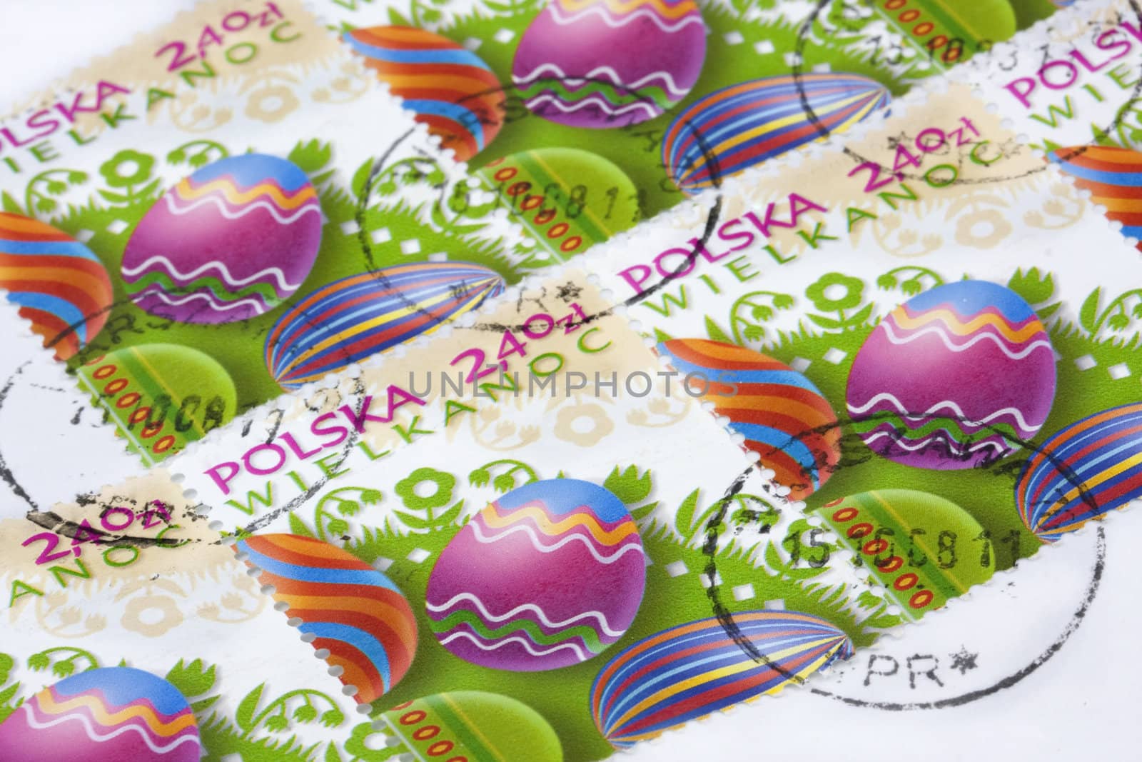 Easter (Wielkanoc) - colorful eggs and floral folk decorations on Polish post stamps canceled in Warsaw with original envelope as background