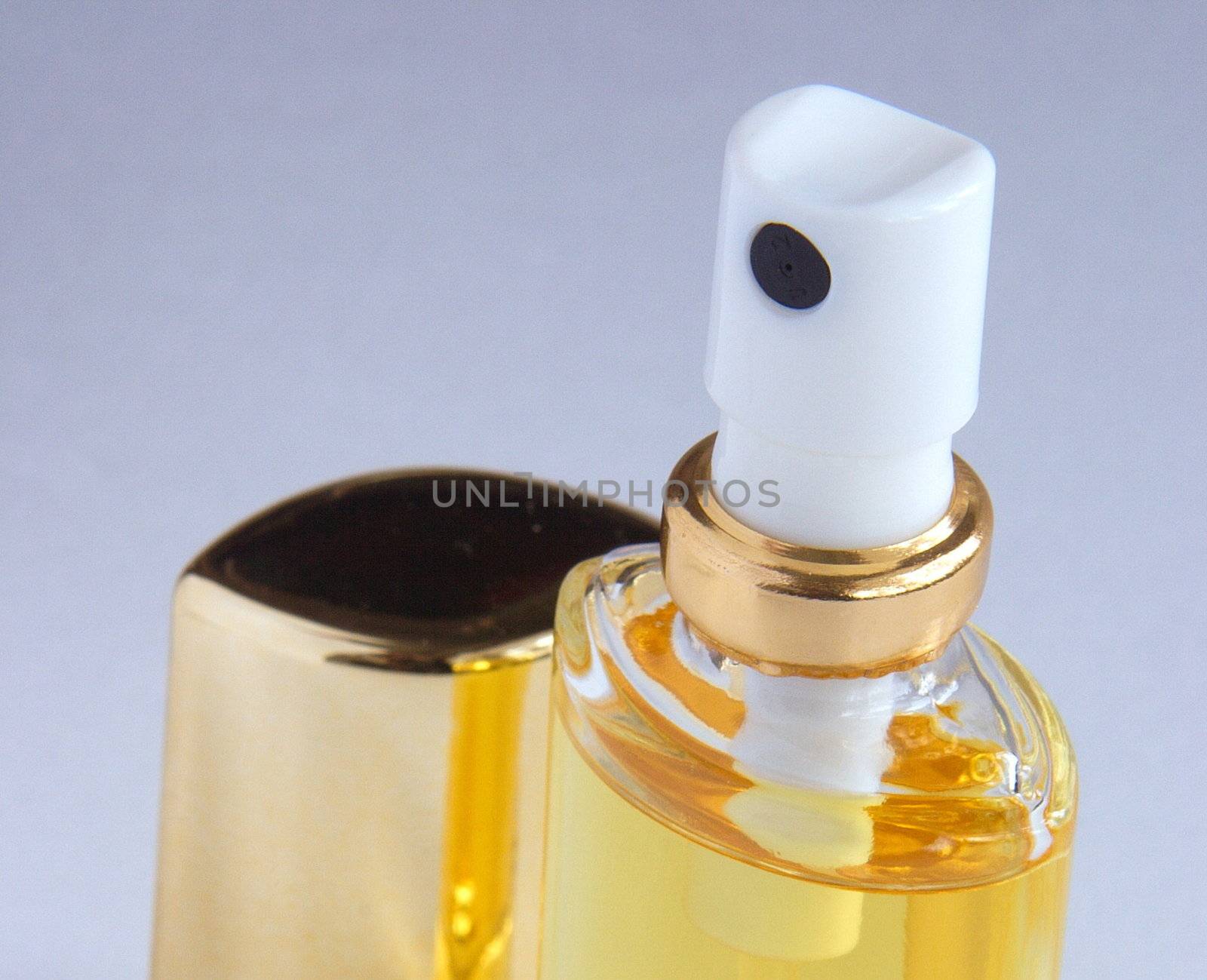 a bottle of perfum spray open with the lid at the side