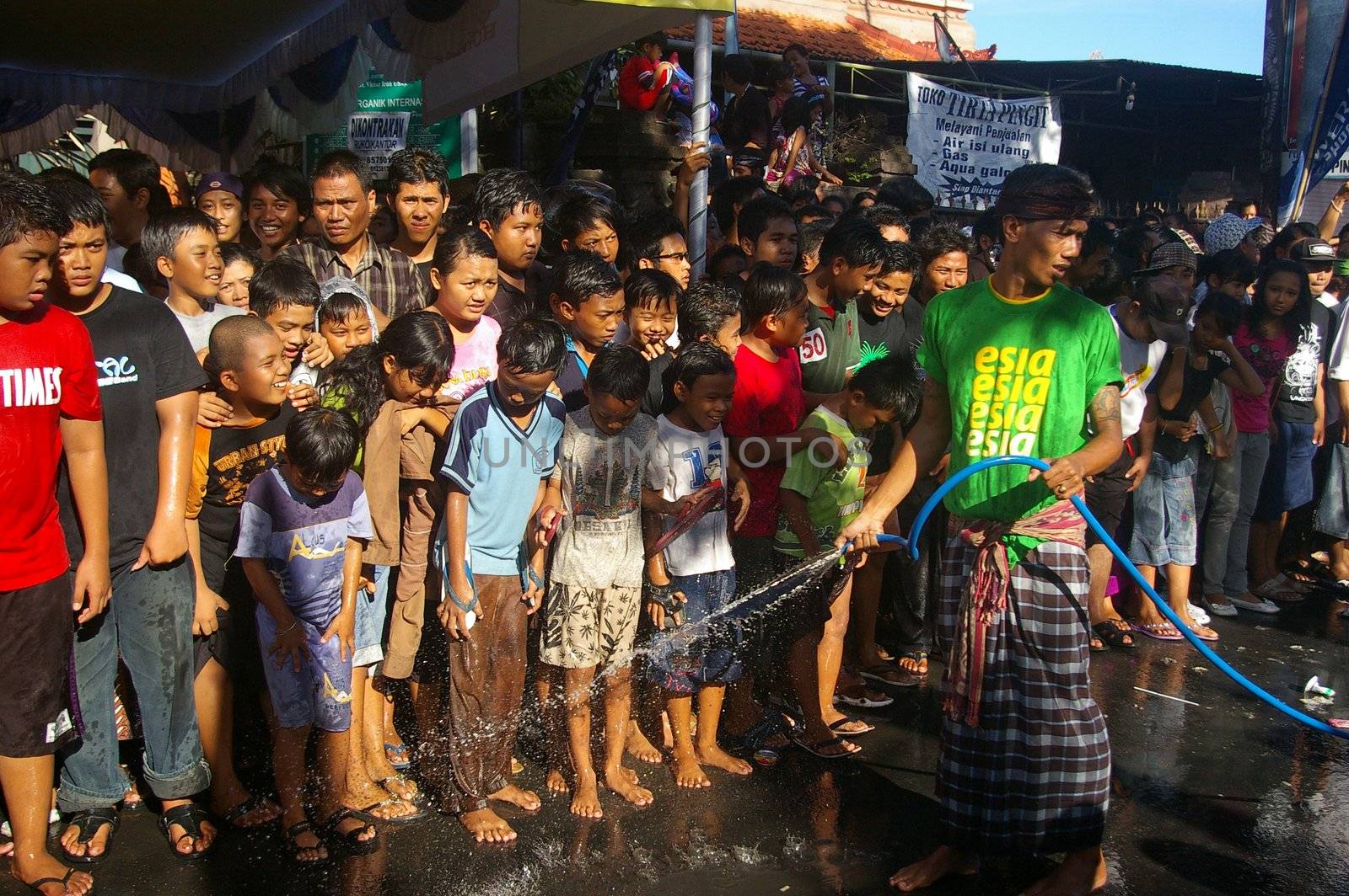 Spectators attending a unique kissing festival, which is said to bring the town good luck, it is also part of Balinese New Year celebrations. Participants as well as spectators are soaked with water. Denpasar, Bali. March 27, 2009. 